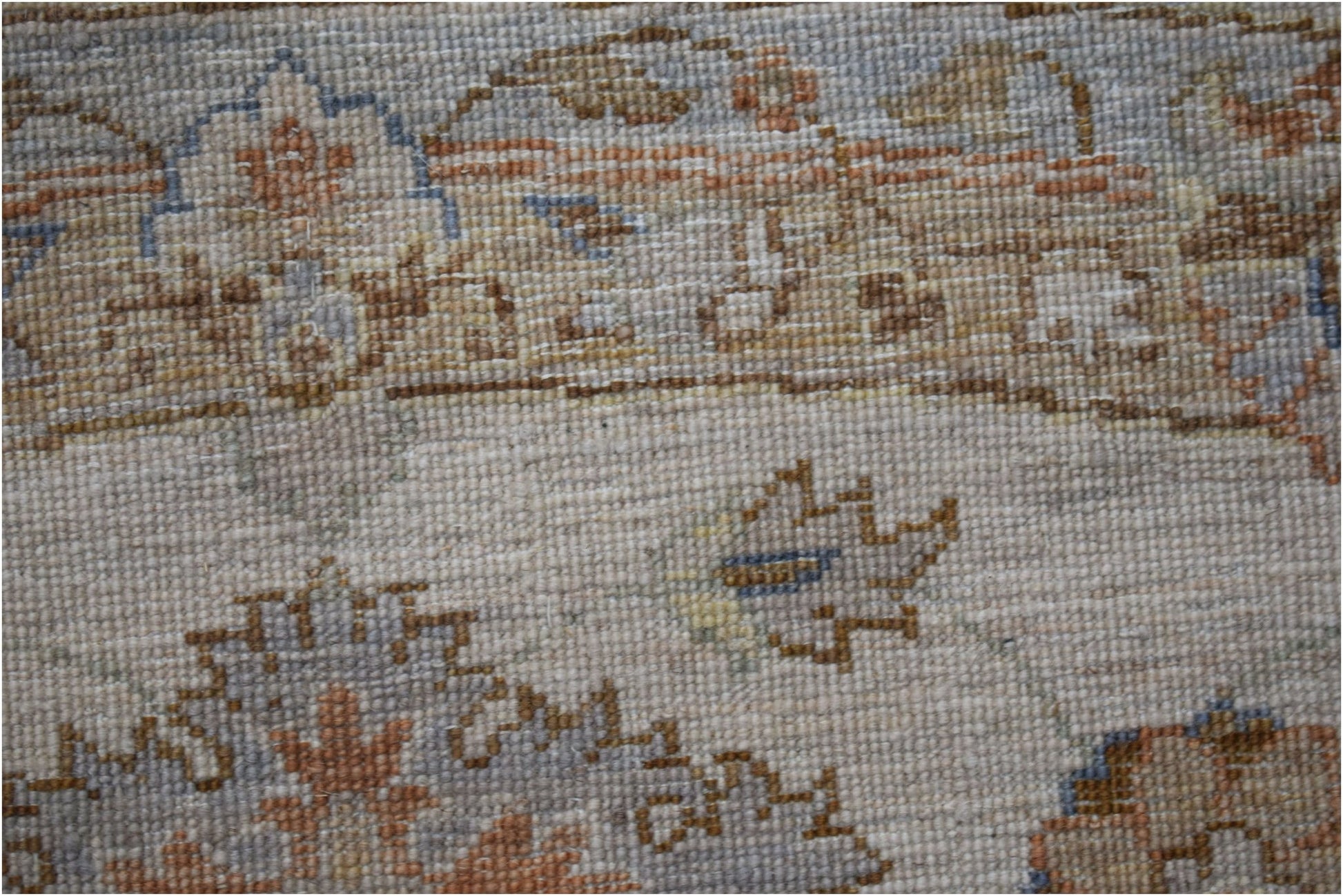 A close-up of a handwoven Afghan Chobi rug featuring traditional floral patterns in earthy tones.
