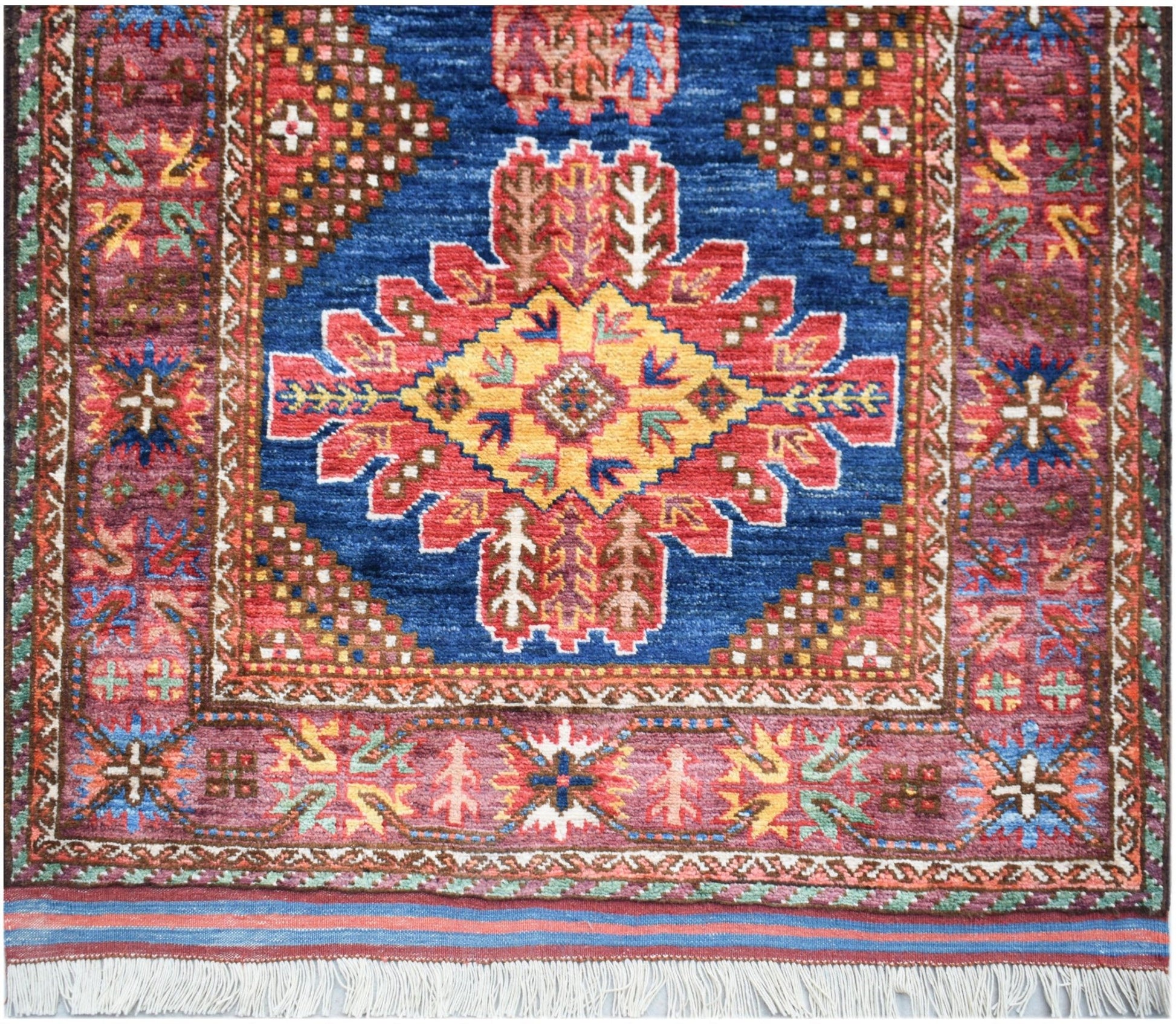 Handwoven Afghan Herati runner featuring a central geometric medallion on a blue field.