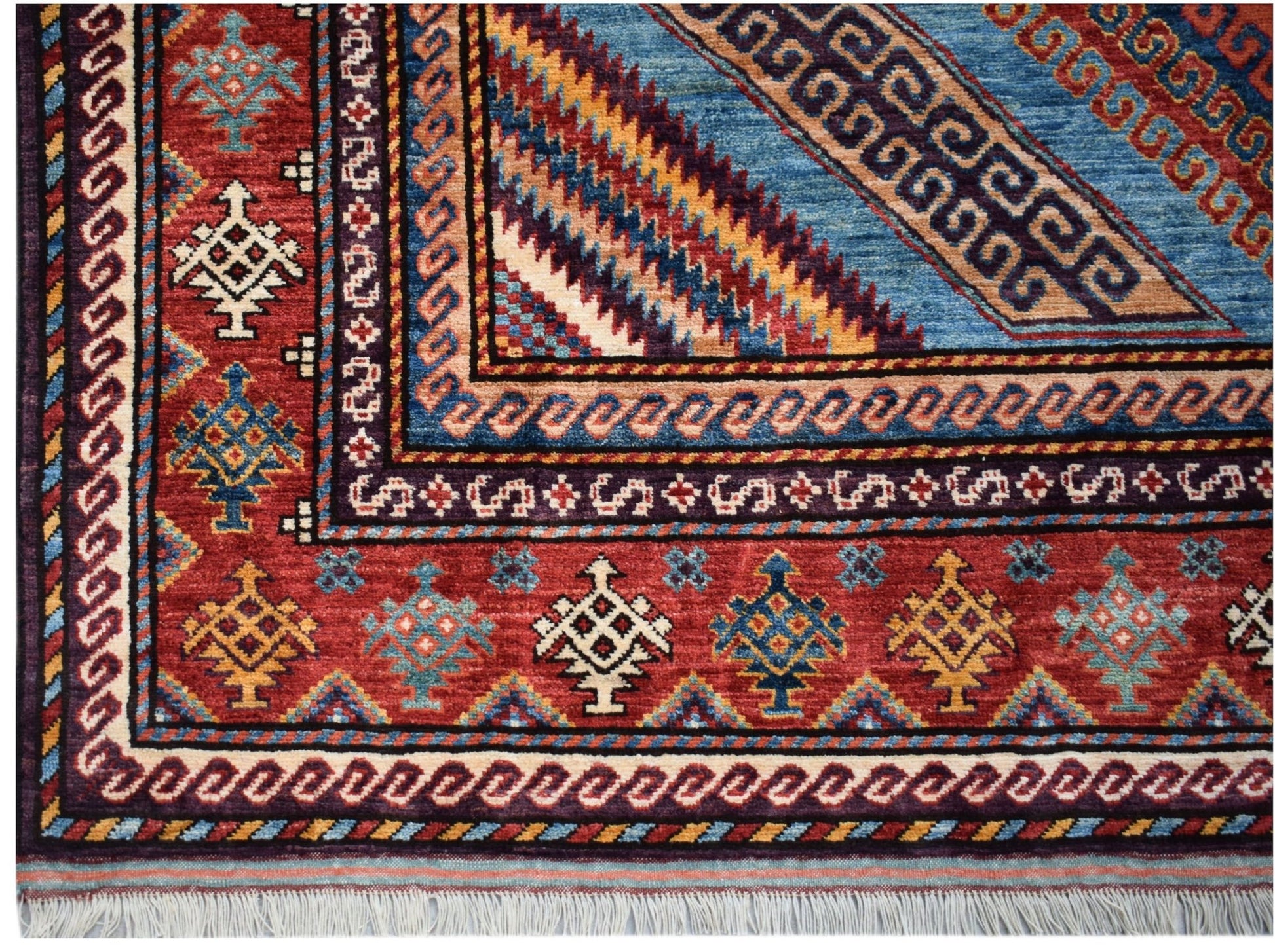 A handwoven Afghan Herati rug featuring intricate geometric patterns in red, blue, and gold.