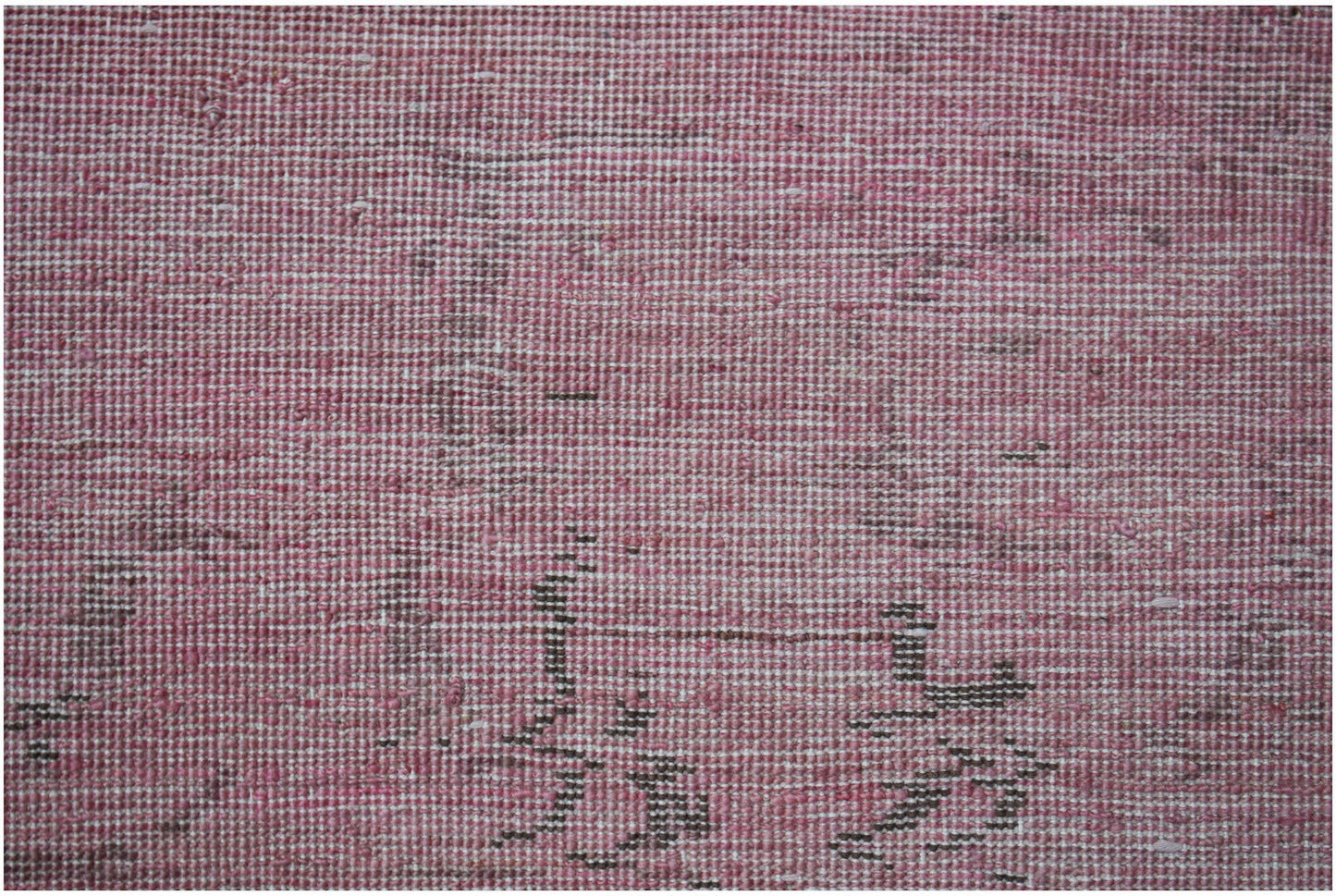 A close-up of a handwoven Afghan Chobi rug featuring a textured pink and brown overdyed pattern.