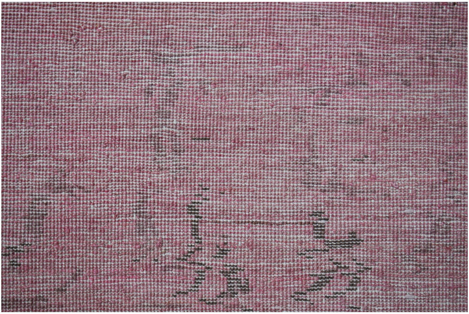 A close-up of a handwoven Afghan Chobi rug featuring a textured pink and brown overdyed pattern.