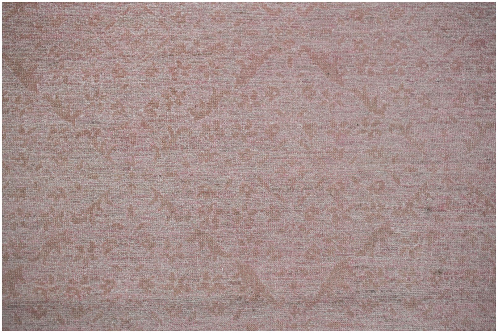 A handmade Afghan Chobi rug featuring a traditional floral pattern in soft pink and beige tones.