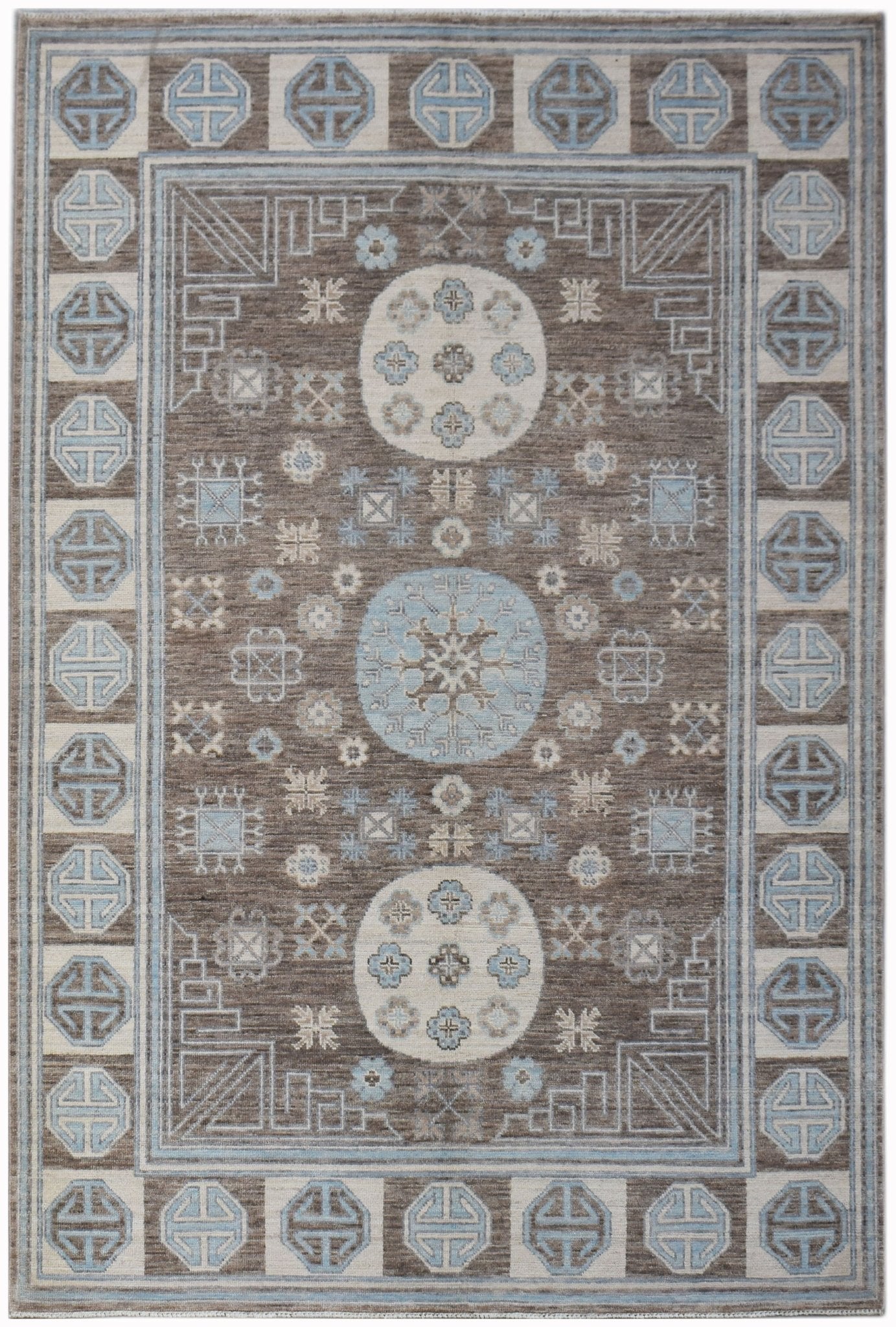 A rectangular transitional Oushak rug featuring a brown field with blue geometric medallions.