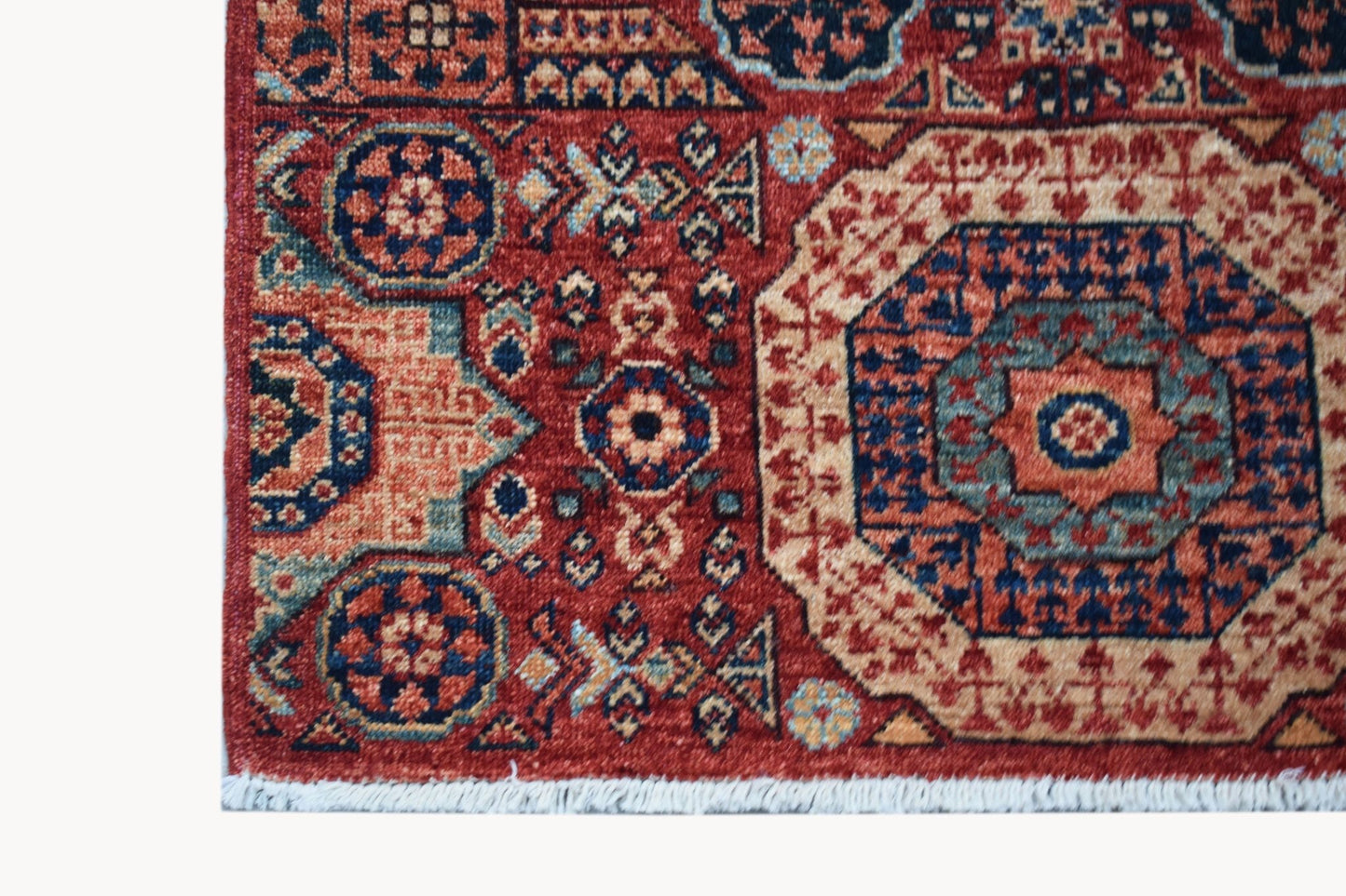 A handmade Afghan Chobi runner featuring a traditional red Mamluk medallion pattern.