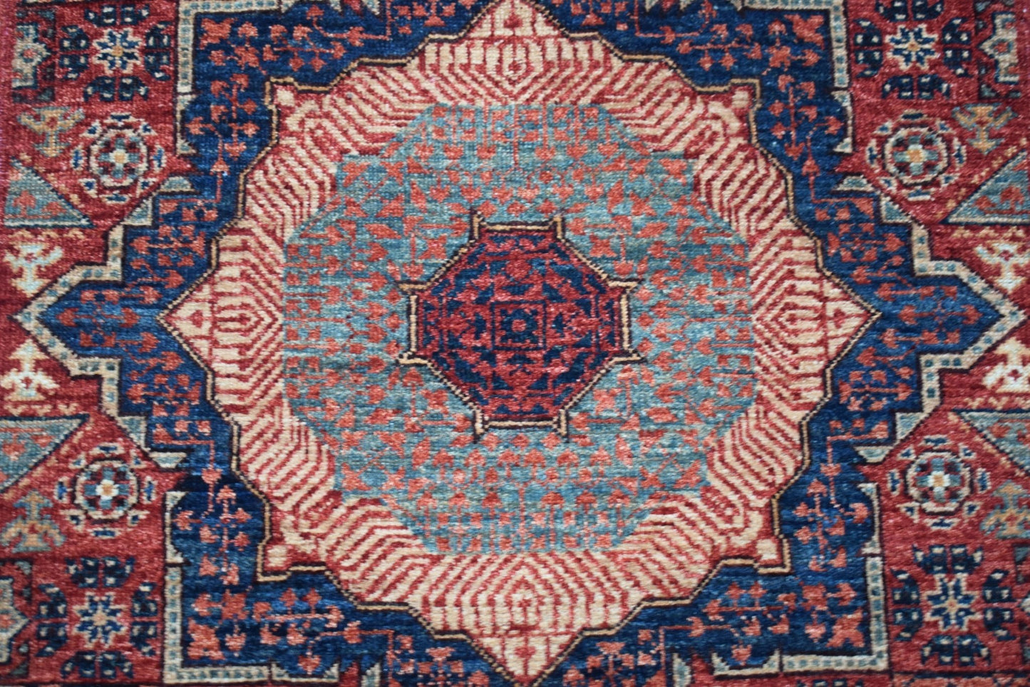 A handmade Afghan Chobi runner featuring a detailed Mamluk medallion in red and blue wool.
