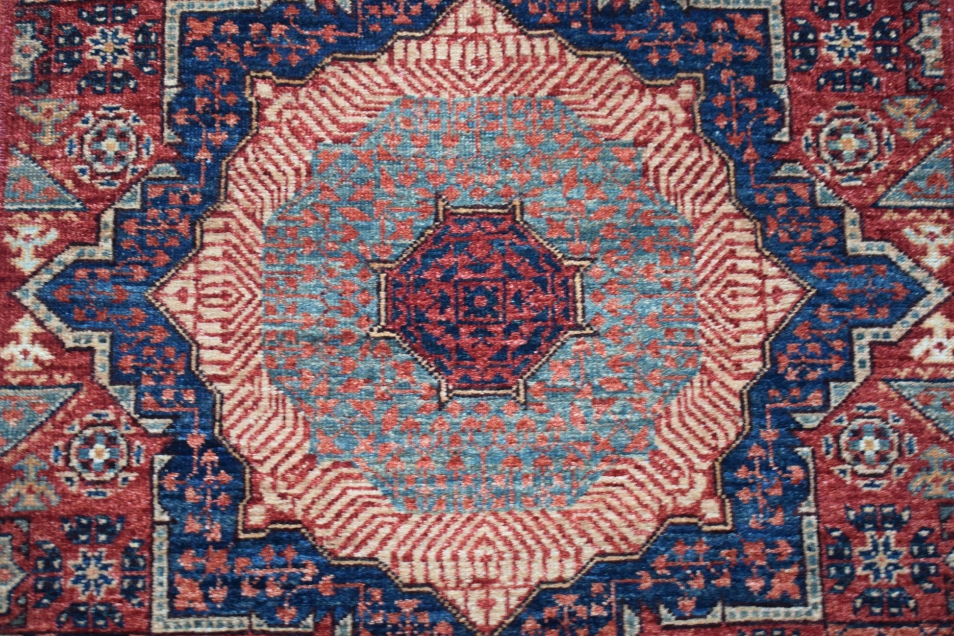 A handmade Afghan Chobi runner featuring a detailed Mamluk medallion in red and blue wool.