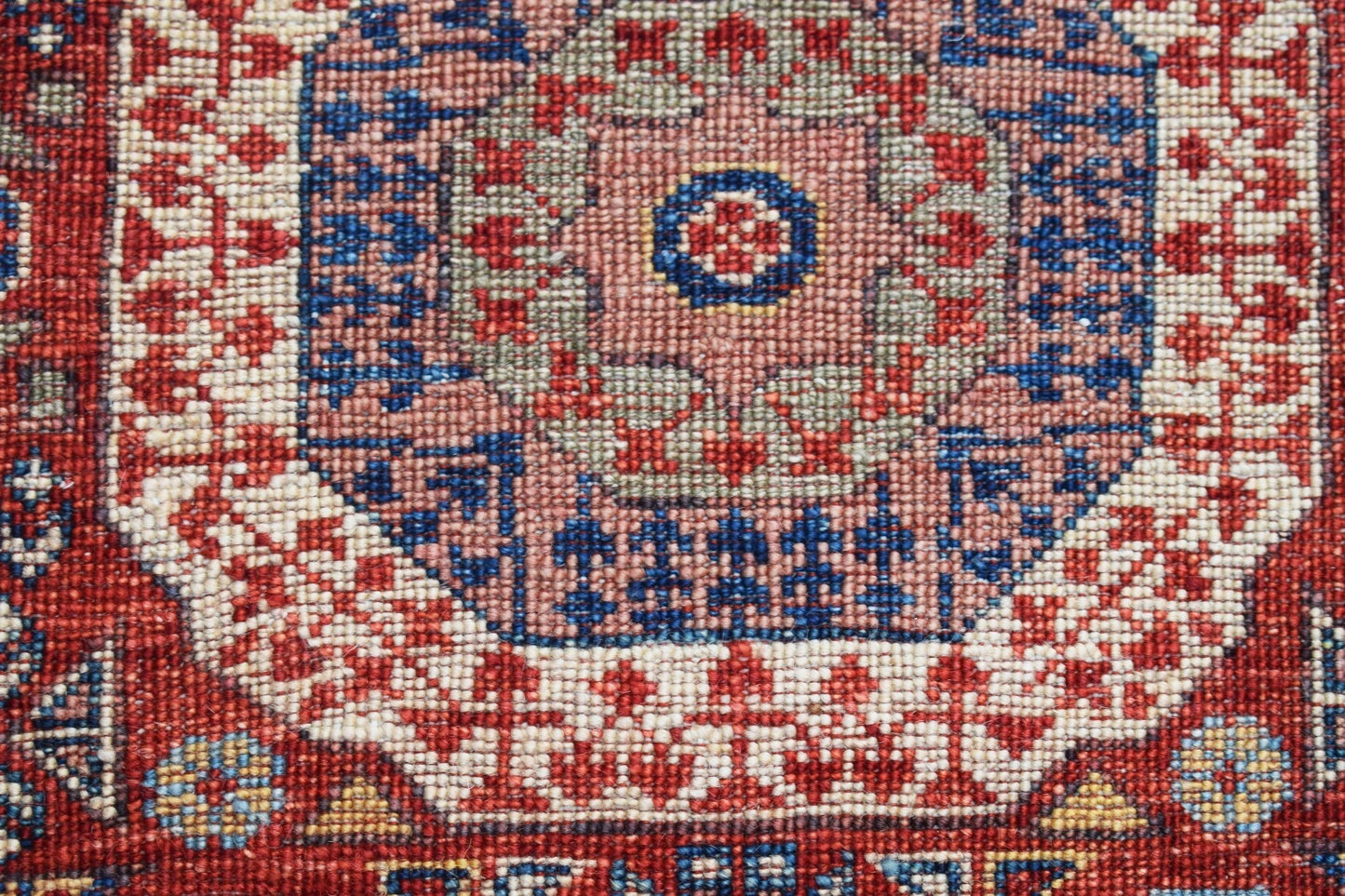 A close-up of a handwoven Afghan Chobi runner featuring a detailed Mamluk medallion pattern.
