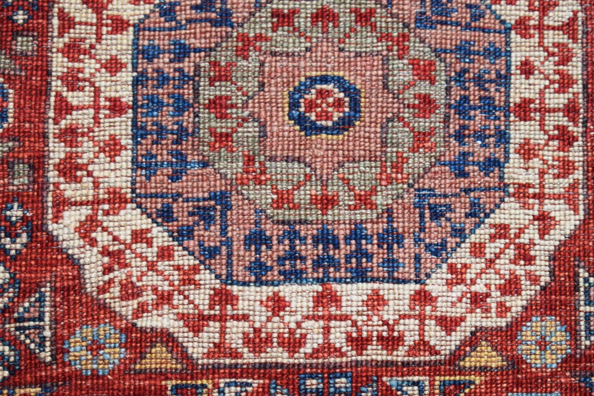 A close-up of a handwoven Afghan Chobi runner featuring a detailed Mamluk medallion pattern.