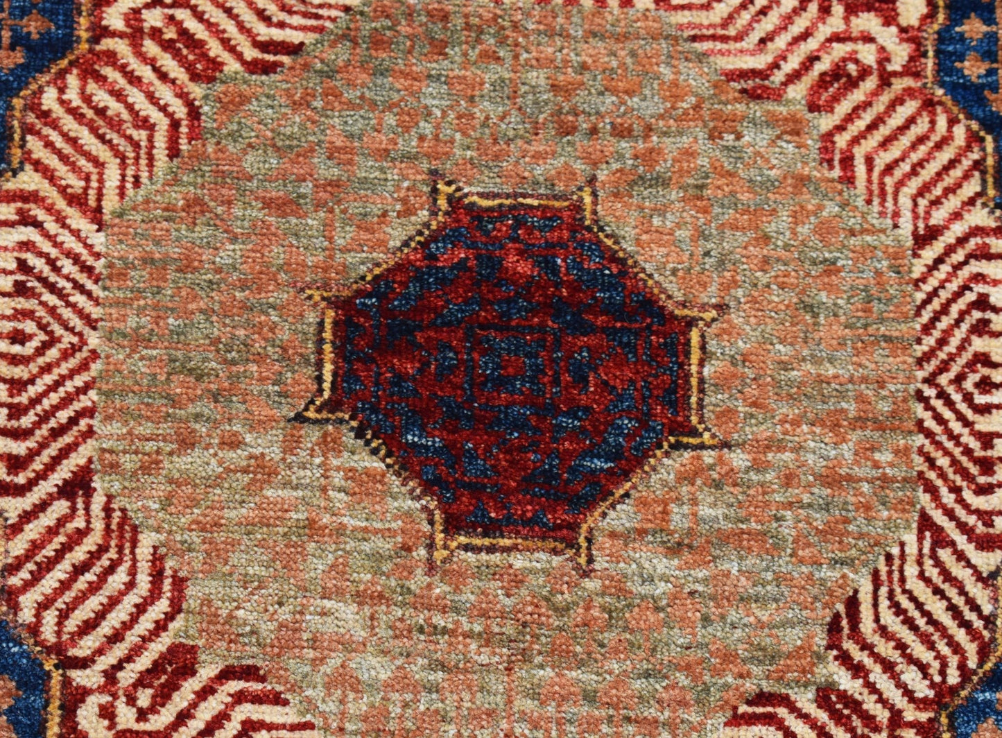 A handwoven Afghan Chobi runner featuring a detailed blue and red Mamluk medallion on a textured tan field.