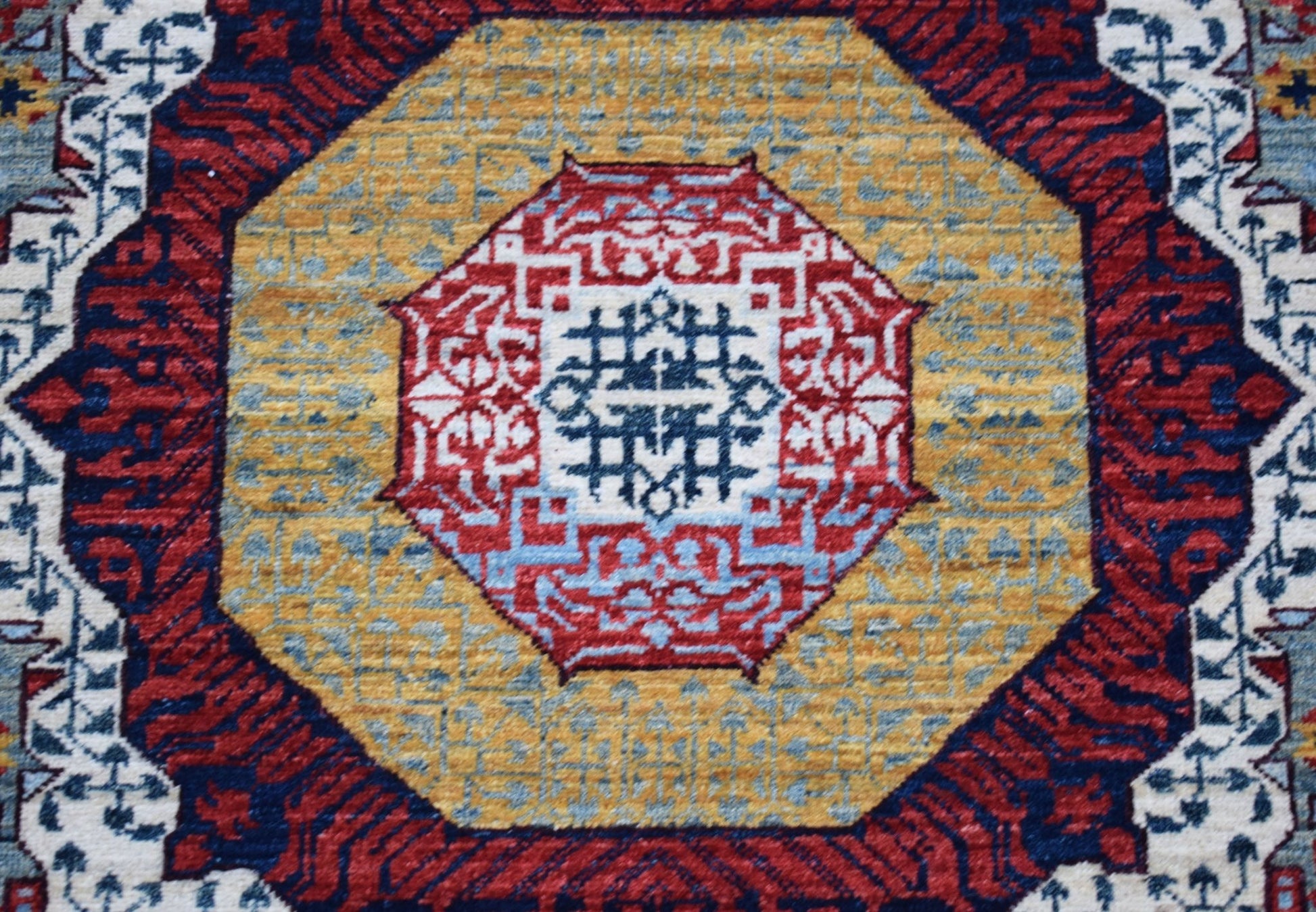 A handwoven Afghan Chobi runner featuring a detailed geometric Mamluk medallion in red and blue.
