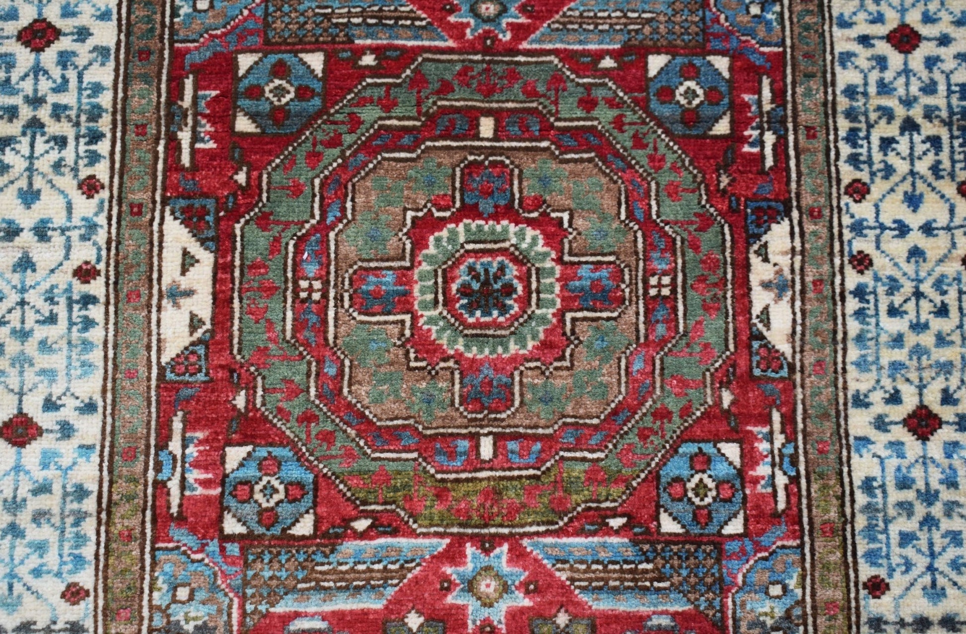 A handmade Afghan Chobi runner featuring a detailed Mamluk medallion pattern in red and blue.