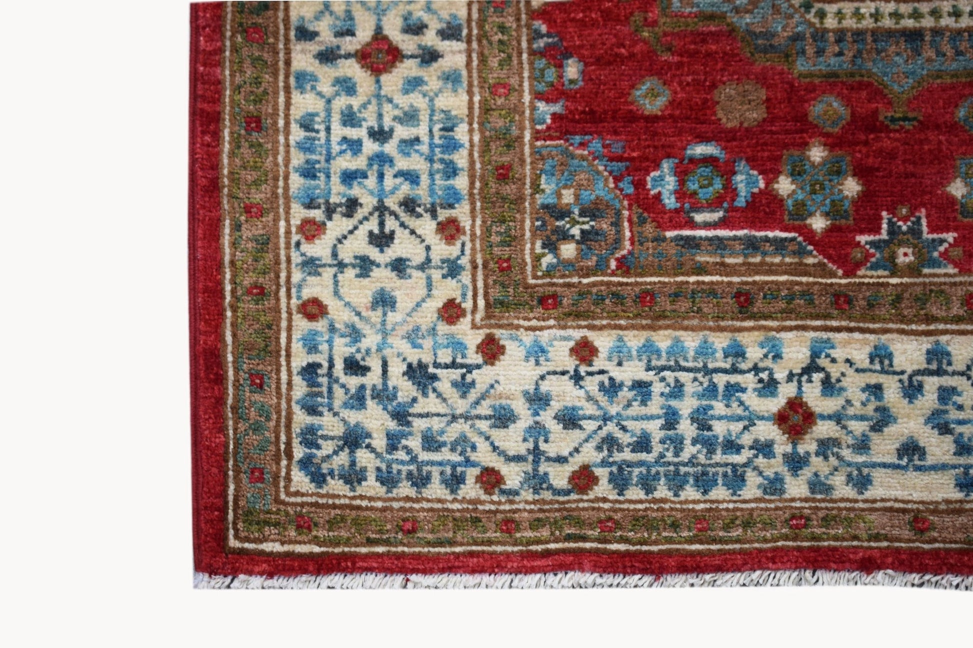 A corner view of a handwoven Afghan Chobi runner featuring a traditional red and blue Mamluk pattern.