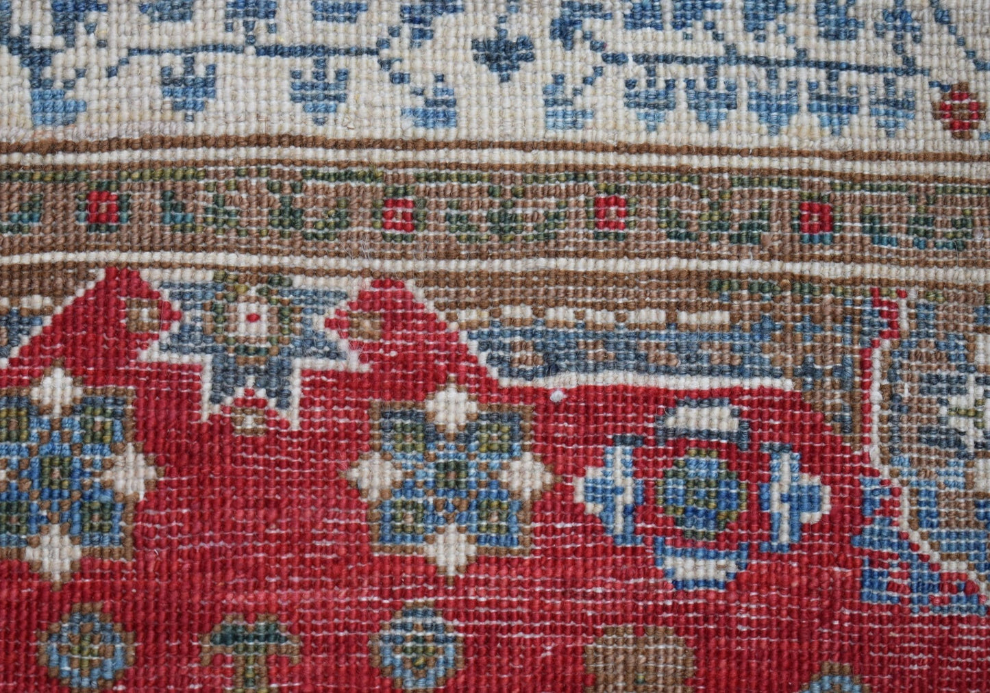 A close-up of a handwoven Afghan Chobi runner featuring a traditional red Mamluk pattern.