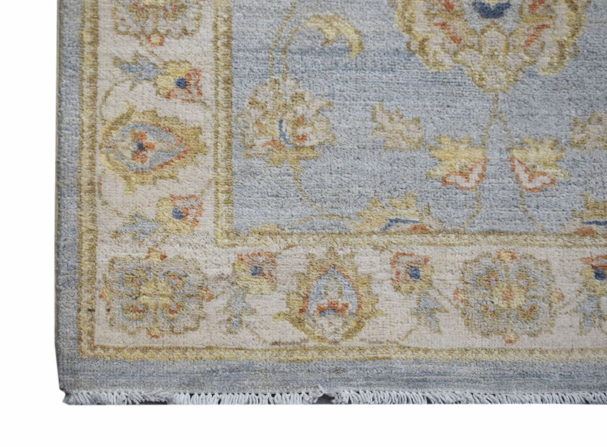 A handmade Afghan Chobi rug featuring a traditional floral pattern in soft blue and cream tones.