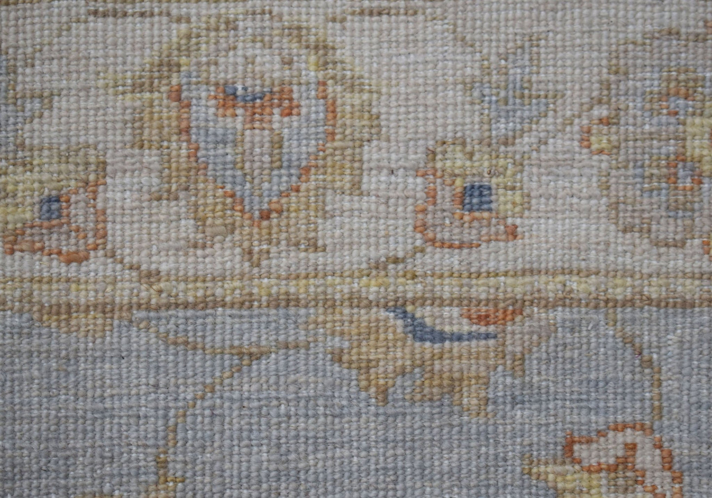 A close-up of a handwoven Afghan Chobi rug featuring traditional floral patterns in earthy tones.