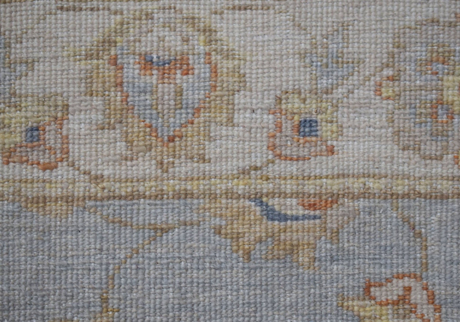 A close-up of a handwoven Afghan Chobi rug featuring traditional floral patterns in earthy tones.