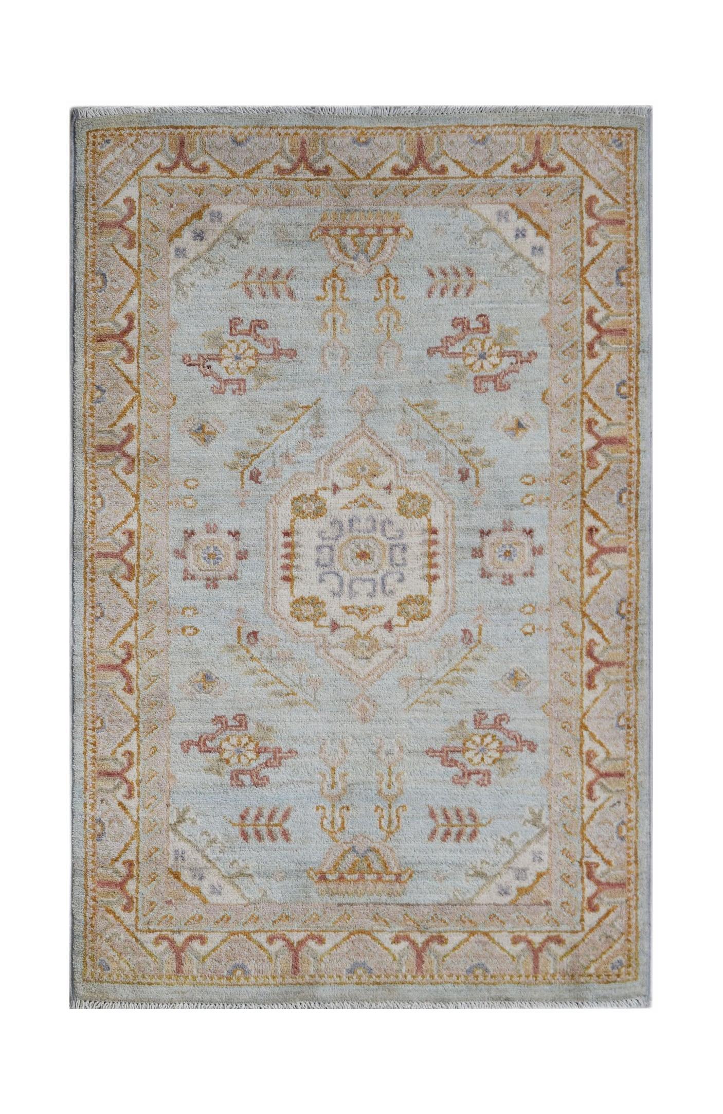 Handwoven Afghan Chobi rug featuring a traditional floral pattern in soft blue and earthy tones.
