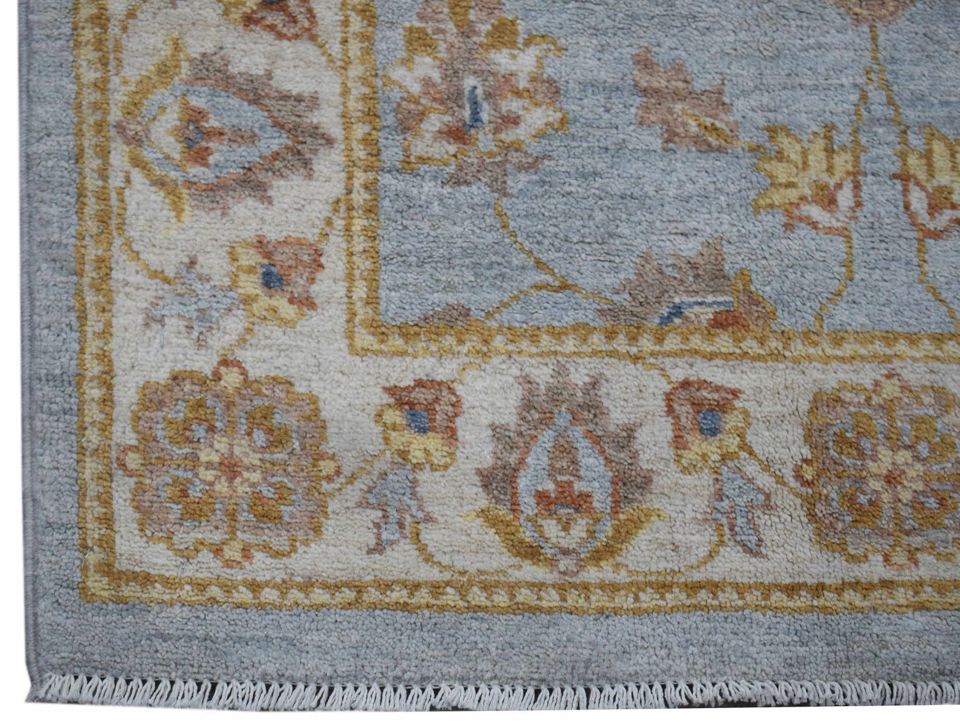 A handwoven Afghan Chobi rug featuring a traditional floral pattern in soft blue and earthy tones.