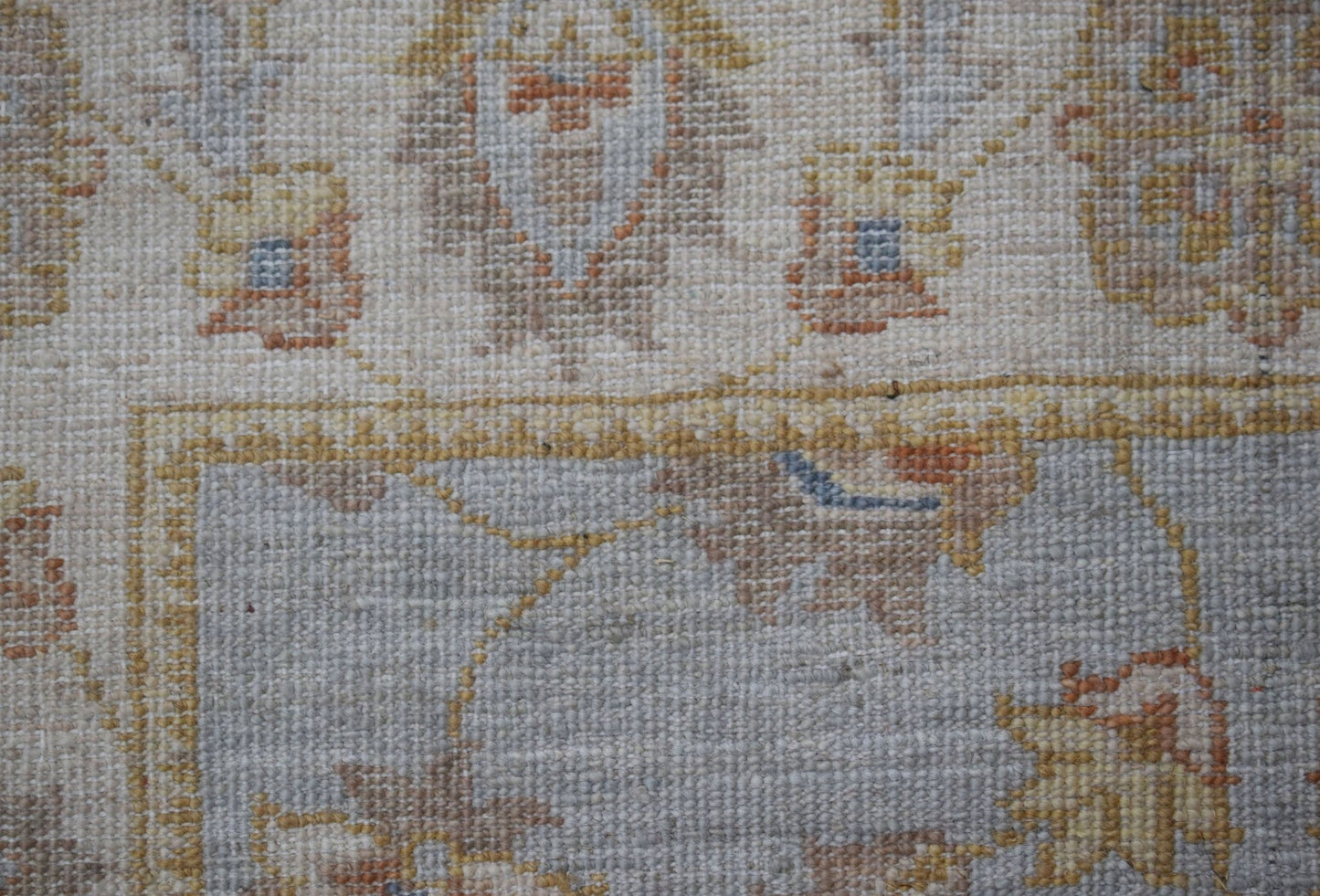 A close-up of a handwoven Afghan Chobi rug featuring traditional floral patterns in muted tones.