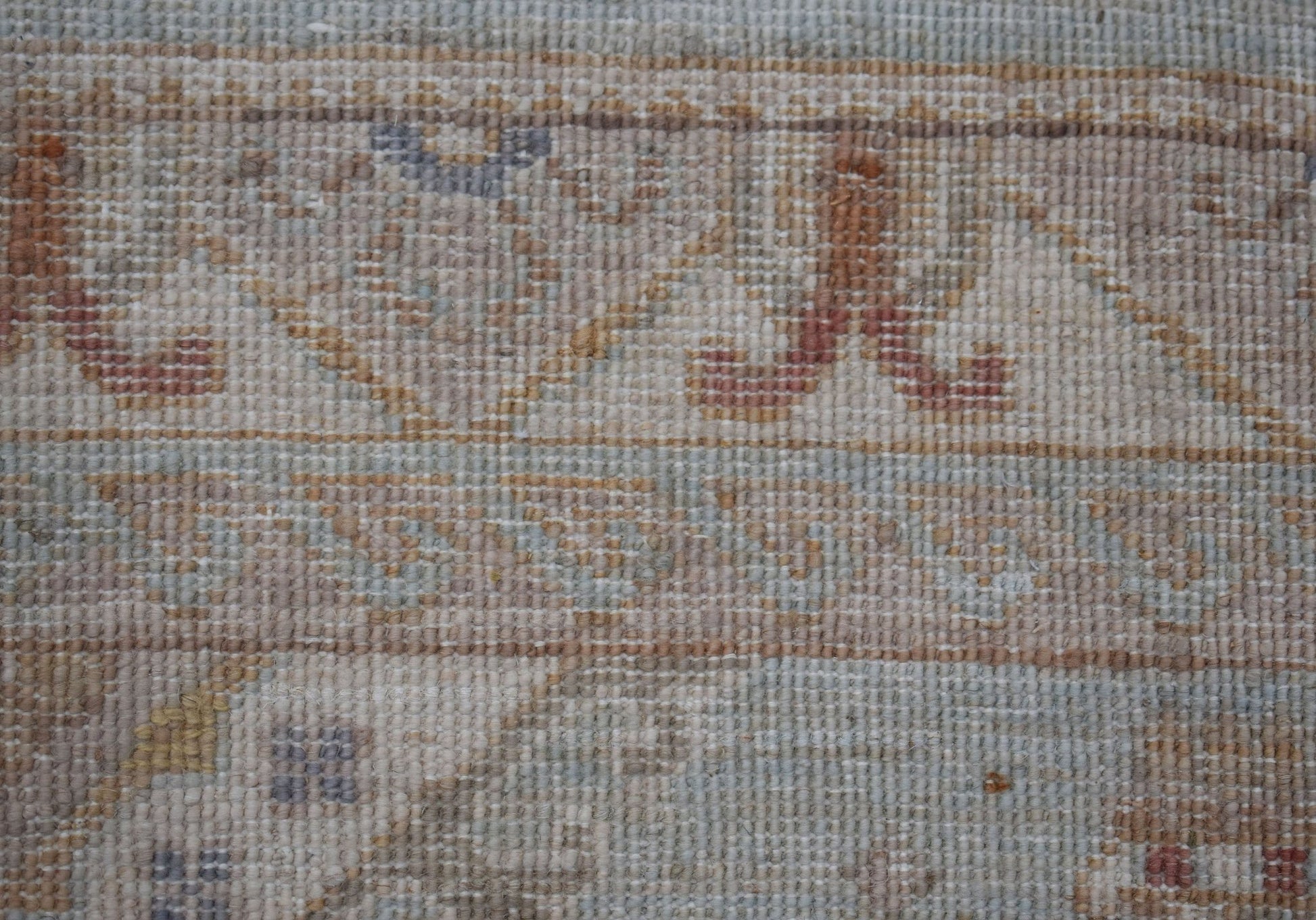 A close-up of an Afghan Chobi rug featuring traditional patterns in muted earthy tones.
