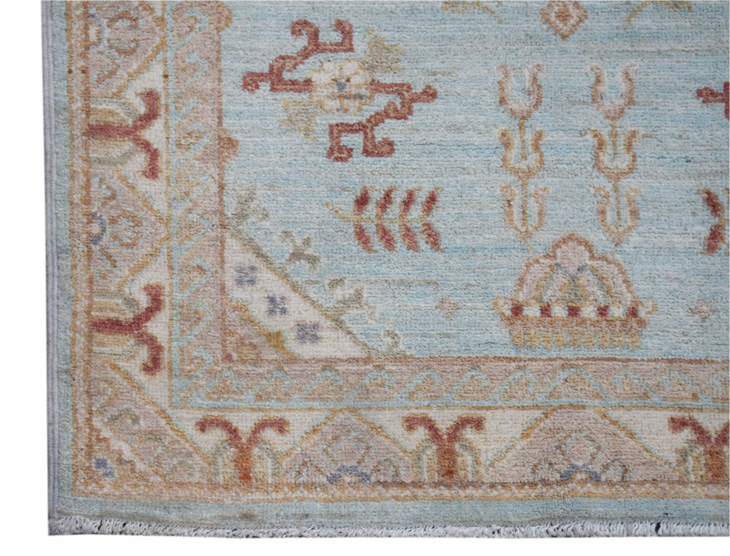 A handwoven Afghan Chobi rug featuring traditional floral motifs in soft blue and earthy tones.