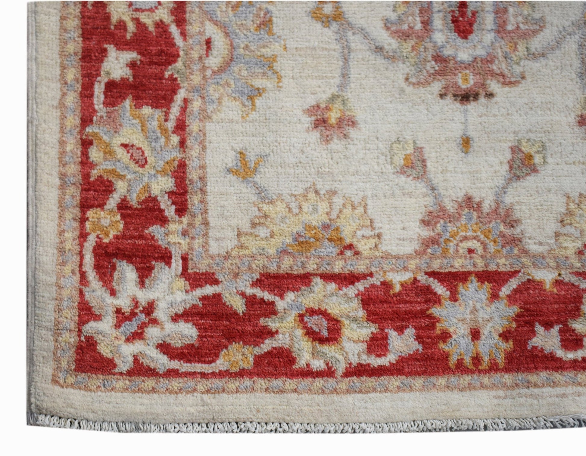 A handmade Afghan Chobi rug featuring a floral pattern in red, cream, and soft earth tones.