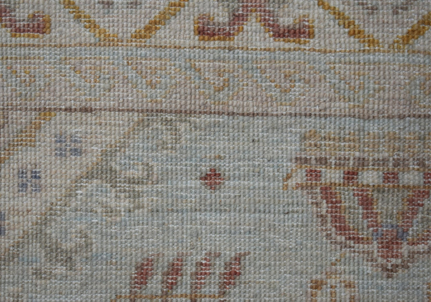 A close-up of a handwoven Afghan Chobi rug featuring traditional patterns in muted earth tones.