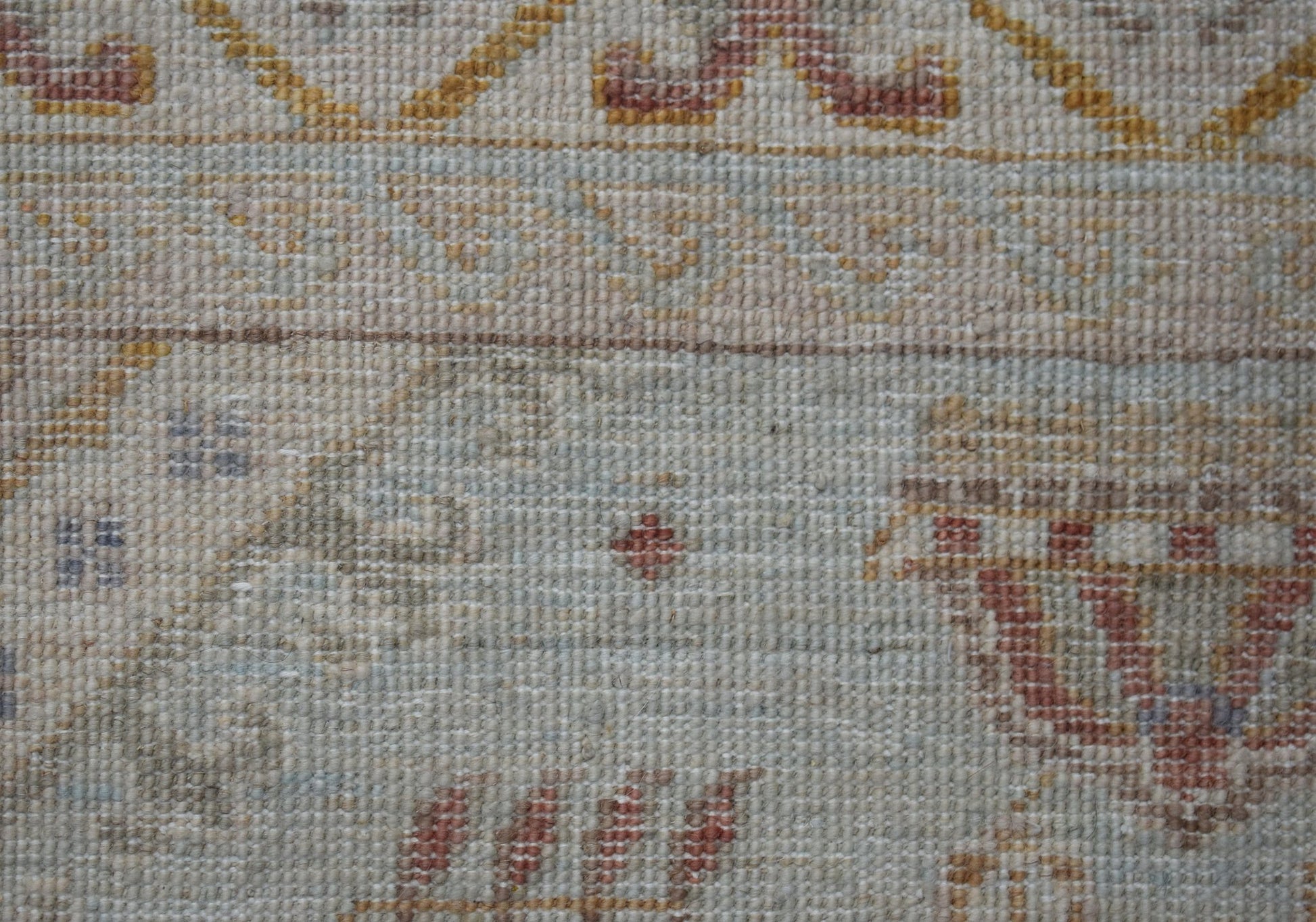 A close-up of a handwoven Afghan Chobi rug featuring traditional patterns in muted earth tones.