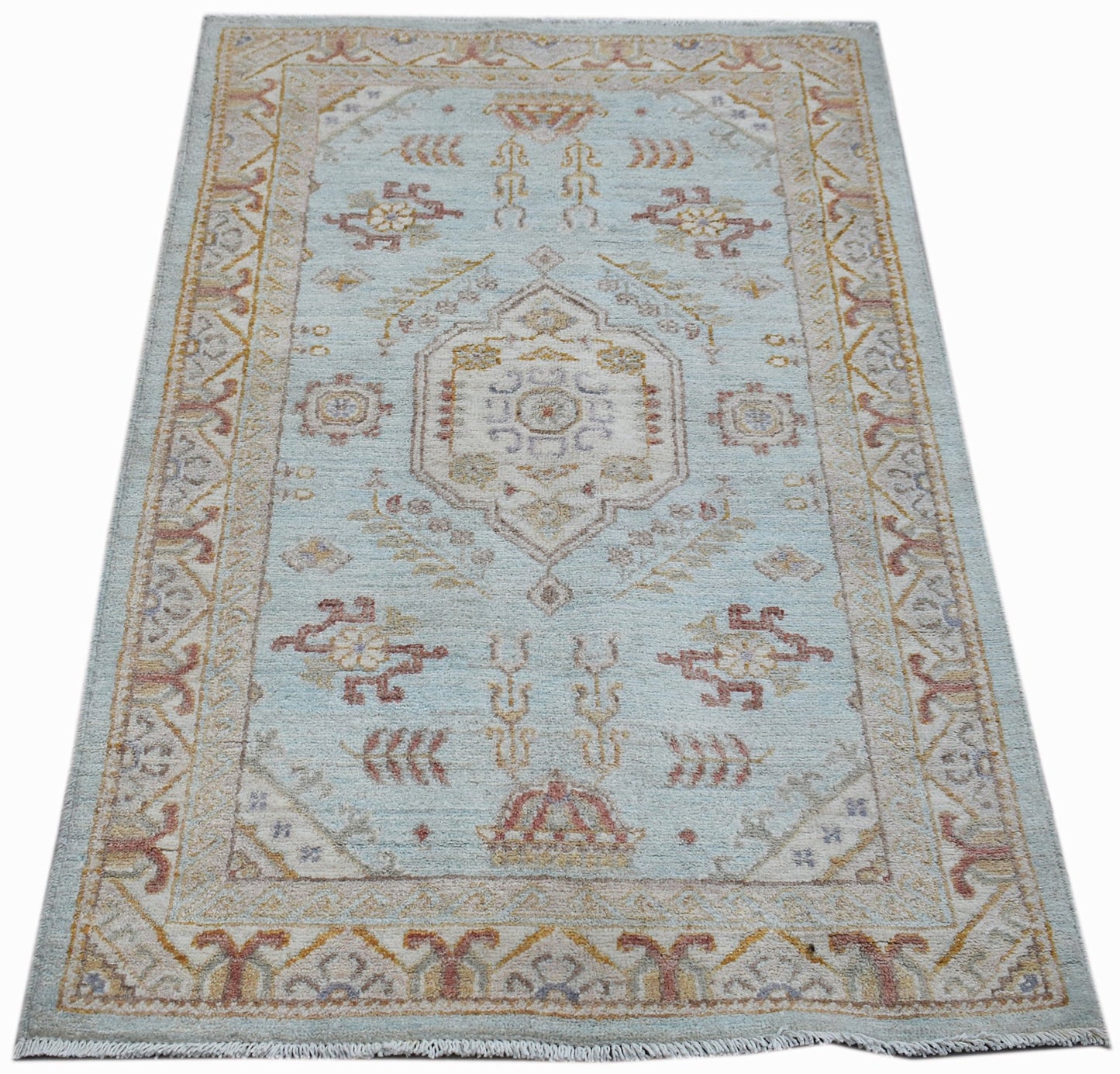 A rectangular Afghan Chobi rug featuring a central medallion on a light blue wool field.
