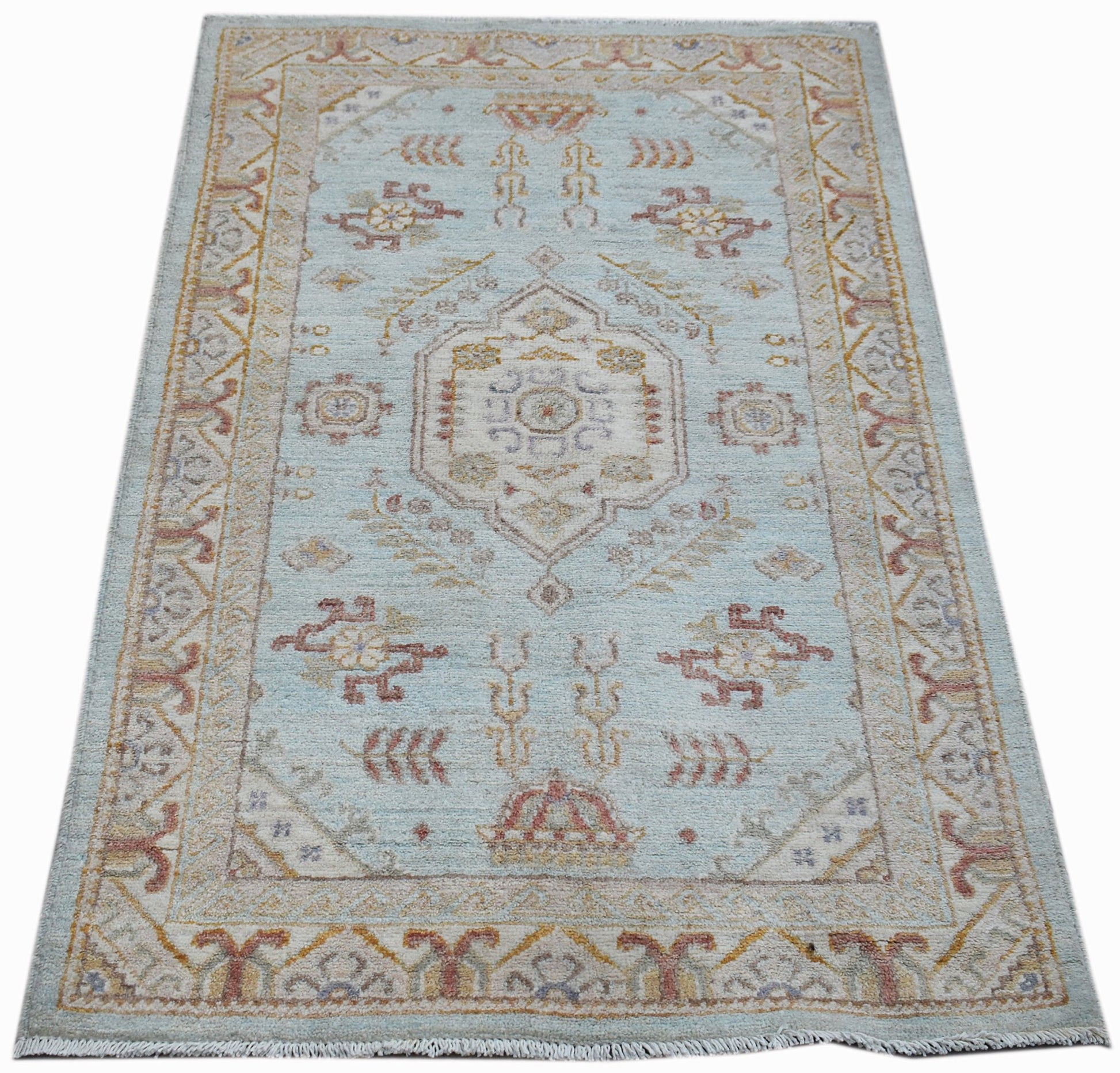 A rectangular Afghan Chobi rug featuring a central medallion on a light blue wool field.
