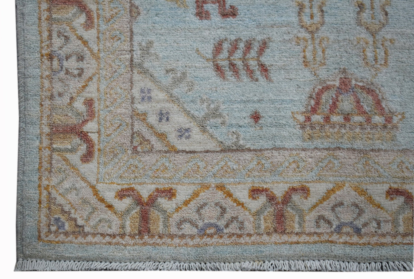 A handwoven Afghan Chobi rug featuring a light blue field with traditional floral motifs.