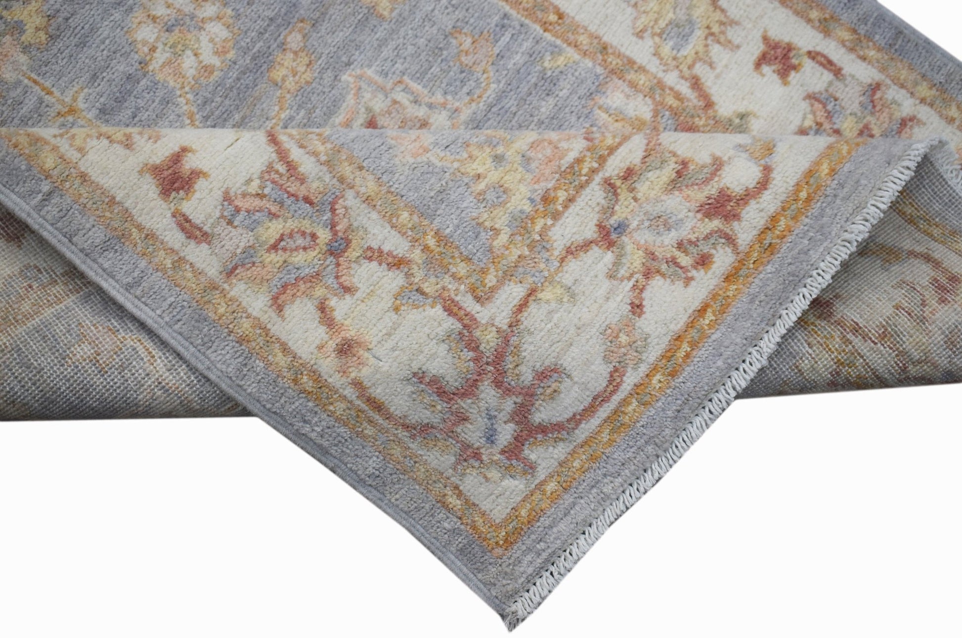 A handmade Afghan Chobi rug featuring a traditional floral pattern in soft blue and cream tones.