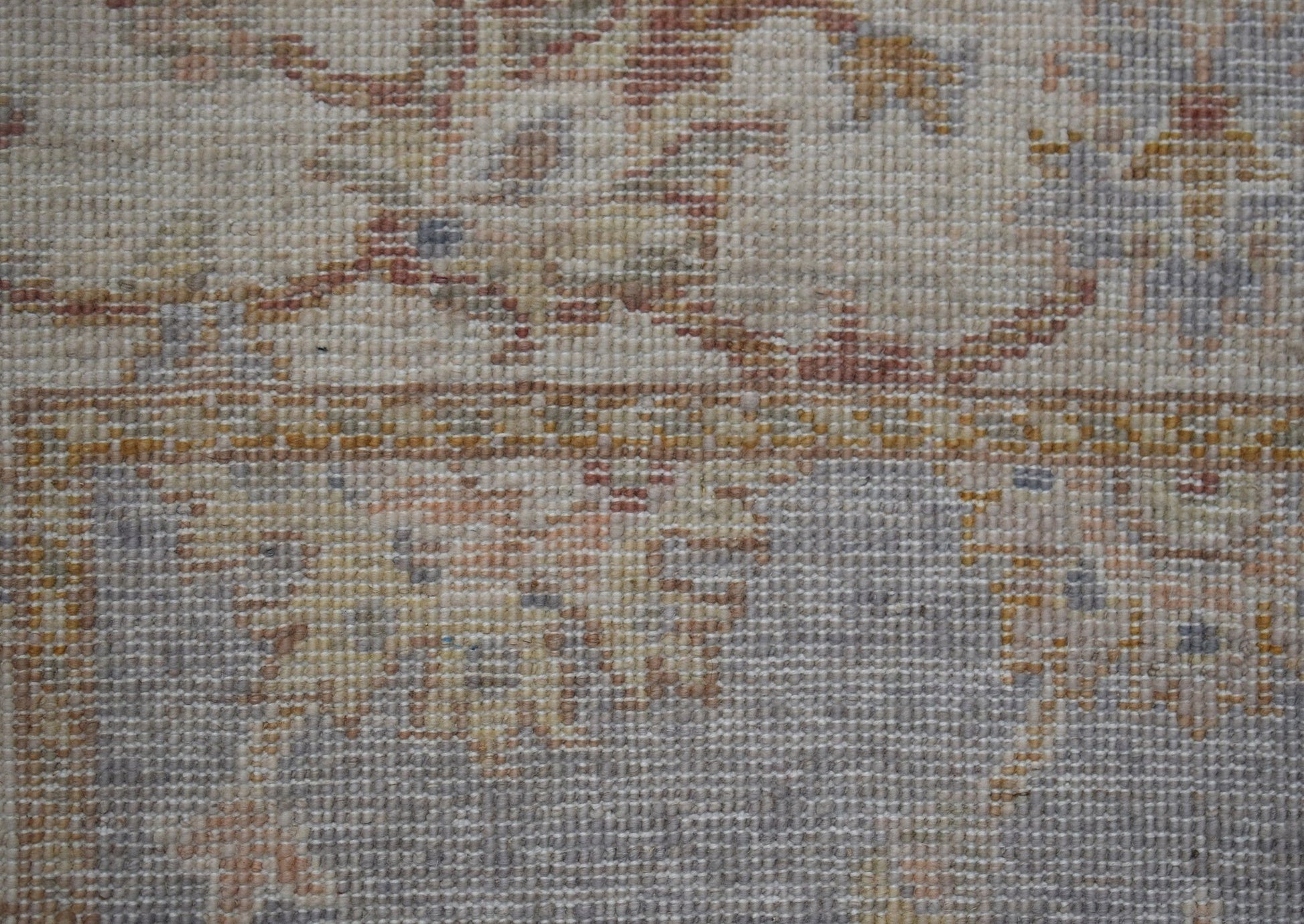 A close-up of a handwoven Afghan Chobi rug featuring a traditional floral pattern in earthy tones.