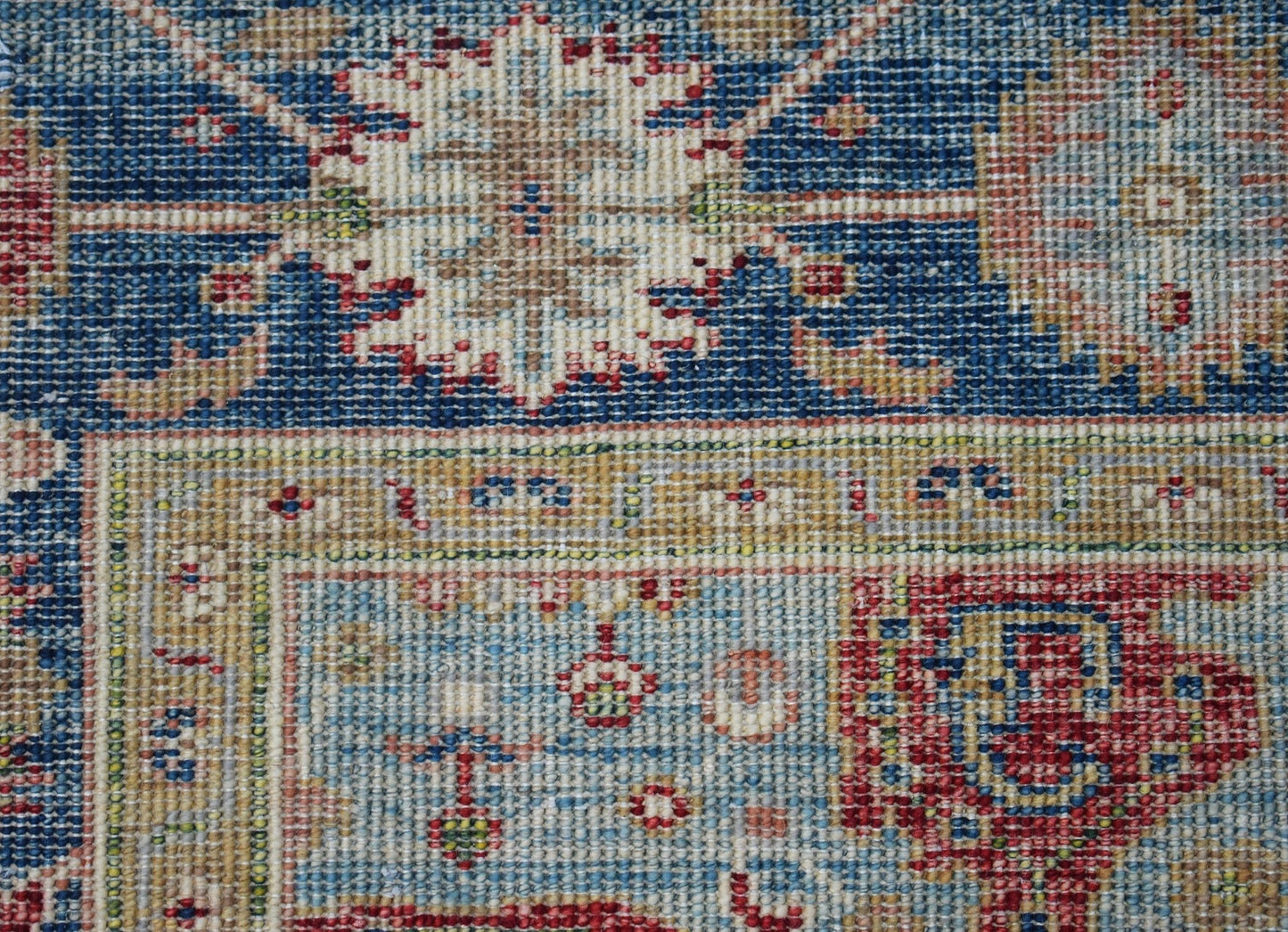 A close-up of a handwoven Afghan Chobi rug featuring intricate floral patterns in blue and red.