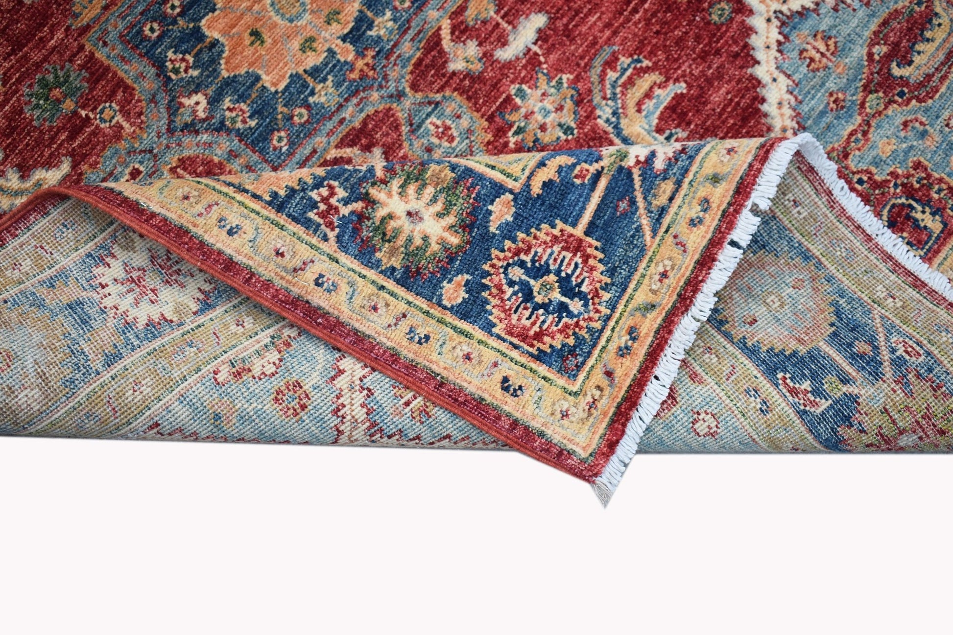 A handwoven Afghan Chobi rug featuring a traditional floral pattern in red, blue, and beige tones.