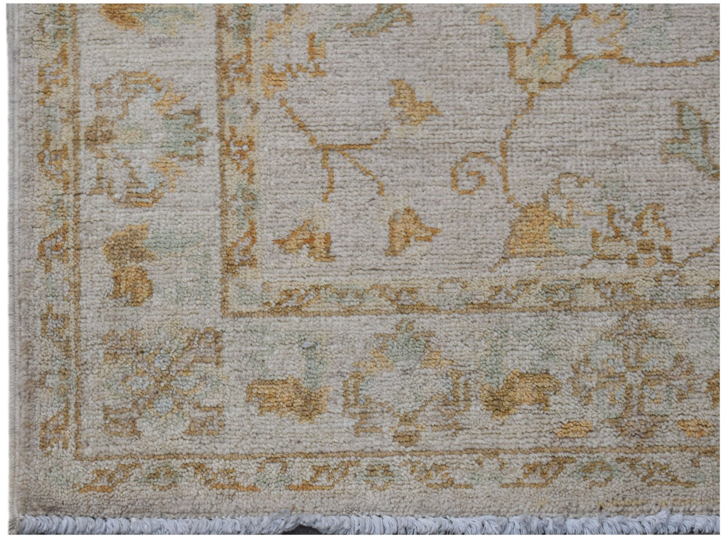 A handwoven Afghan Chobi rug featuring traditional floral patterns in soft beige and gold tones.