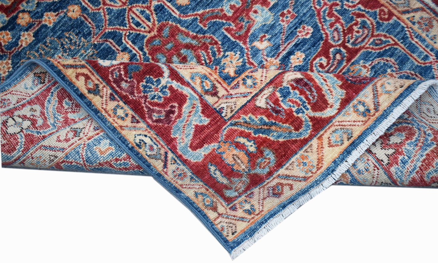 A handwoven Afghan Chobi rug featuring a traditional floral pattern in blue, red, and cream tones.