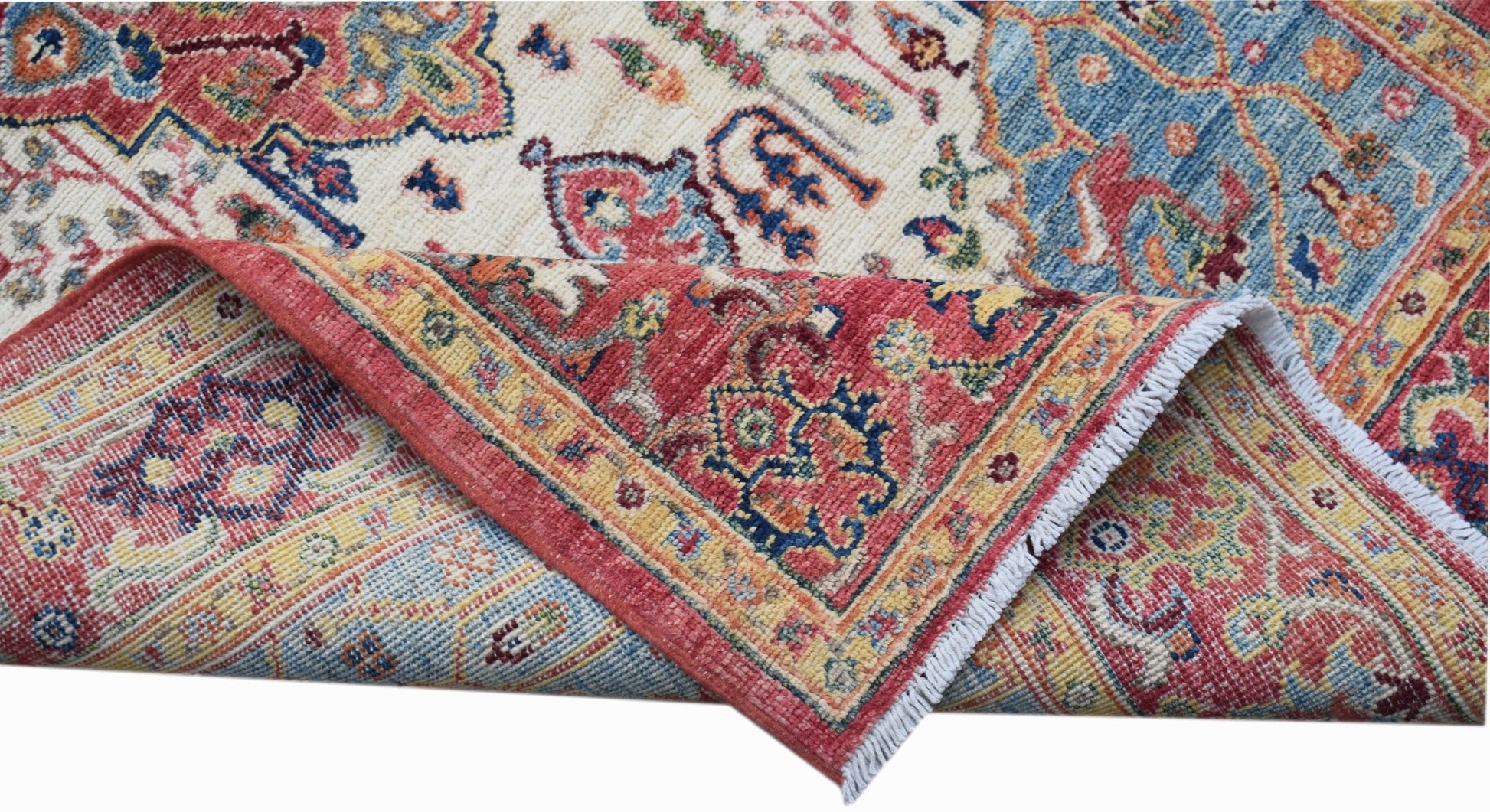 A handwoven Afghan Chobi rug featuring a traditional Heriz pattern in red, blue, and cream tones.