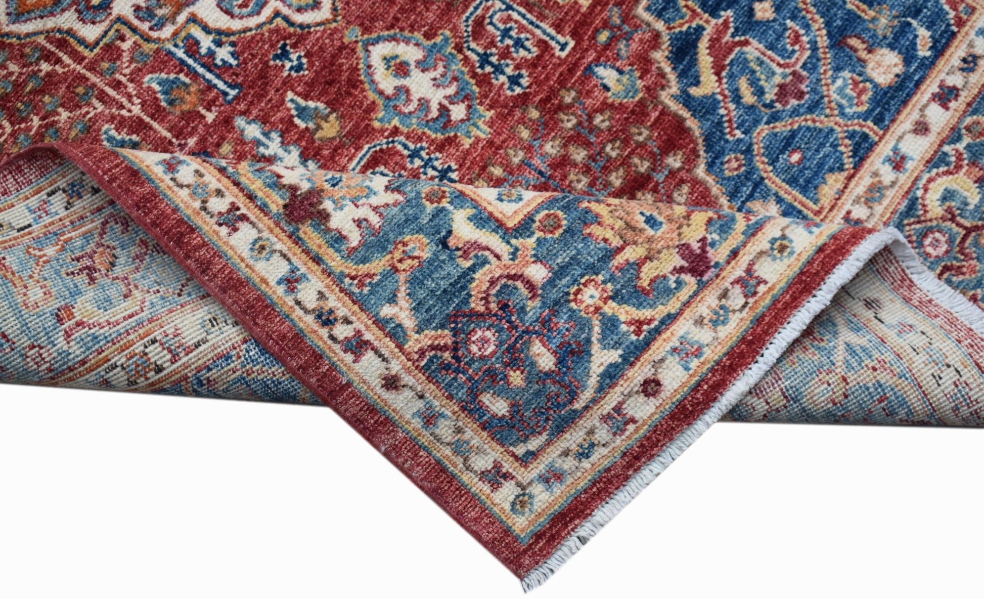 A handmade Afghan Chobi rug with a traditional Heriz pattern in red and blue wool.