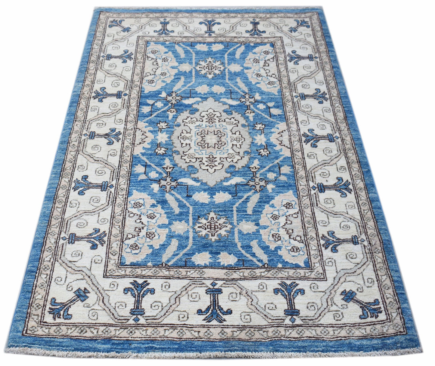 A rectangular Afghan Chobi rug featuring a blue and cream floral pattern with a decorative border.