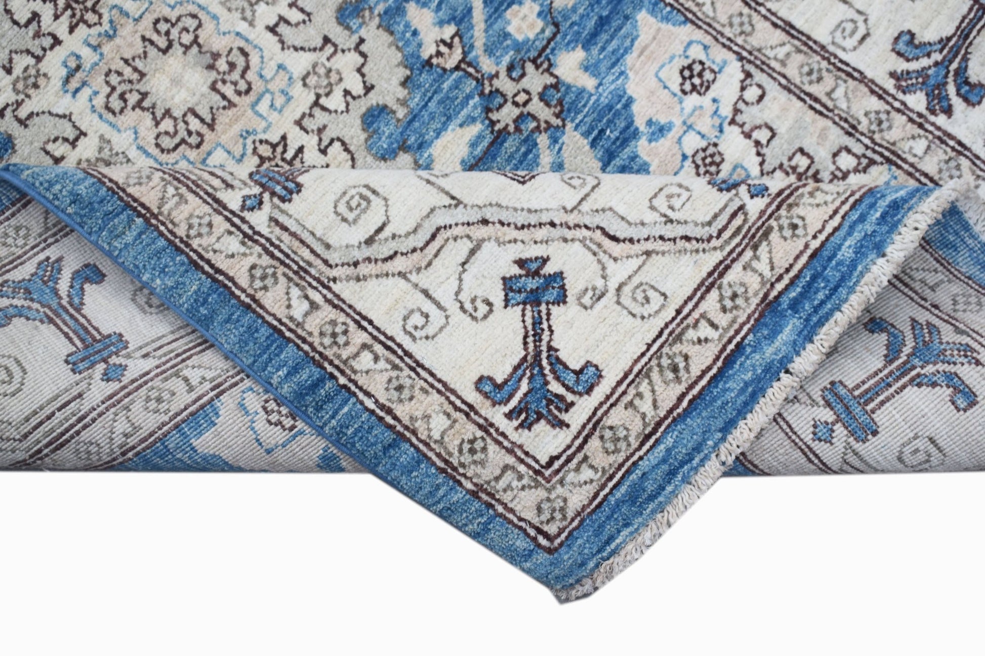 A handwoven Afghan Chobi rug featuring a traditional blue and cream floral pattern.