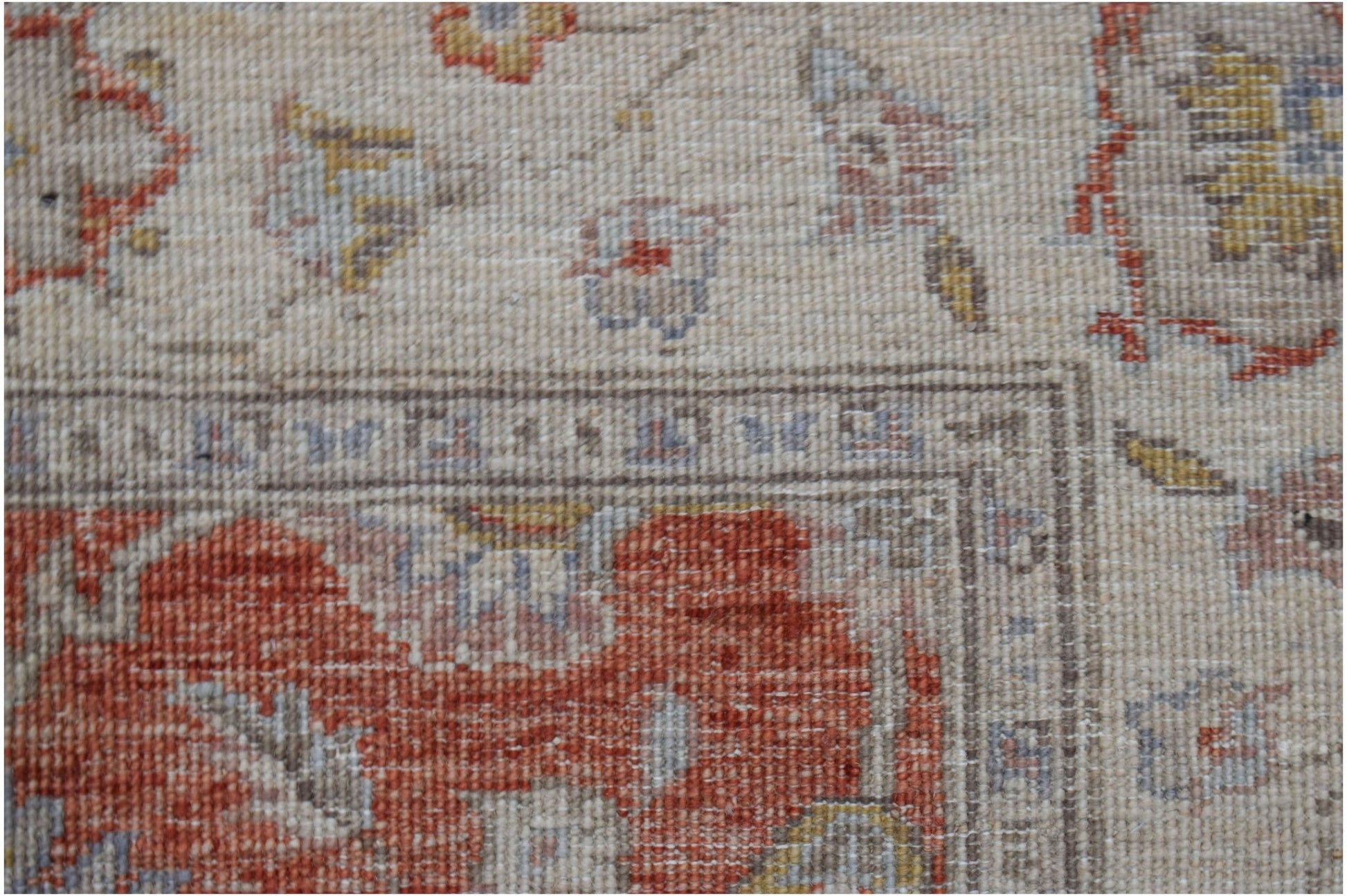 A close-up of a handwoven Afghan Chobi rug featuring traditional floral patterns in earthy tones.
