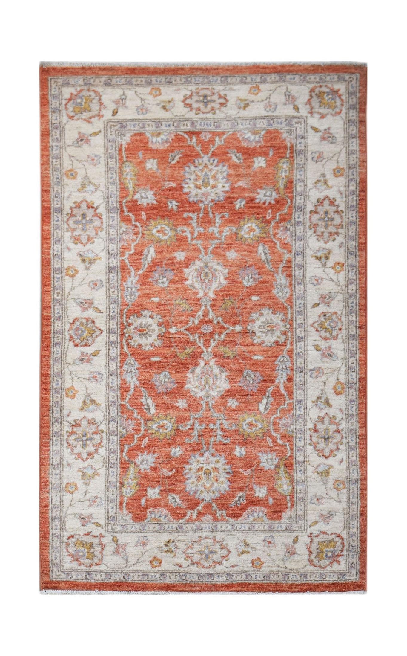 Handmade Afghan Chobi rug featuring a traditional floral pattern in rust orange and cream tones.