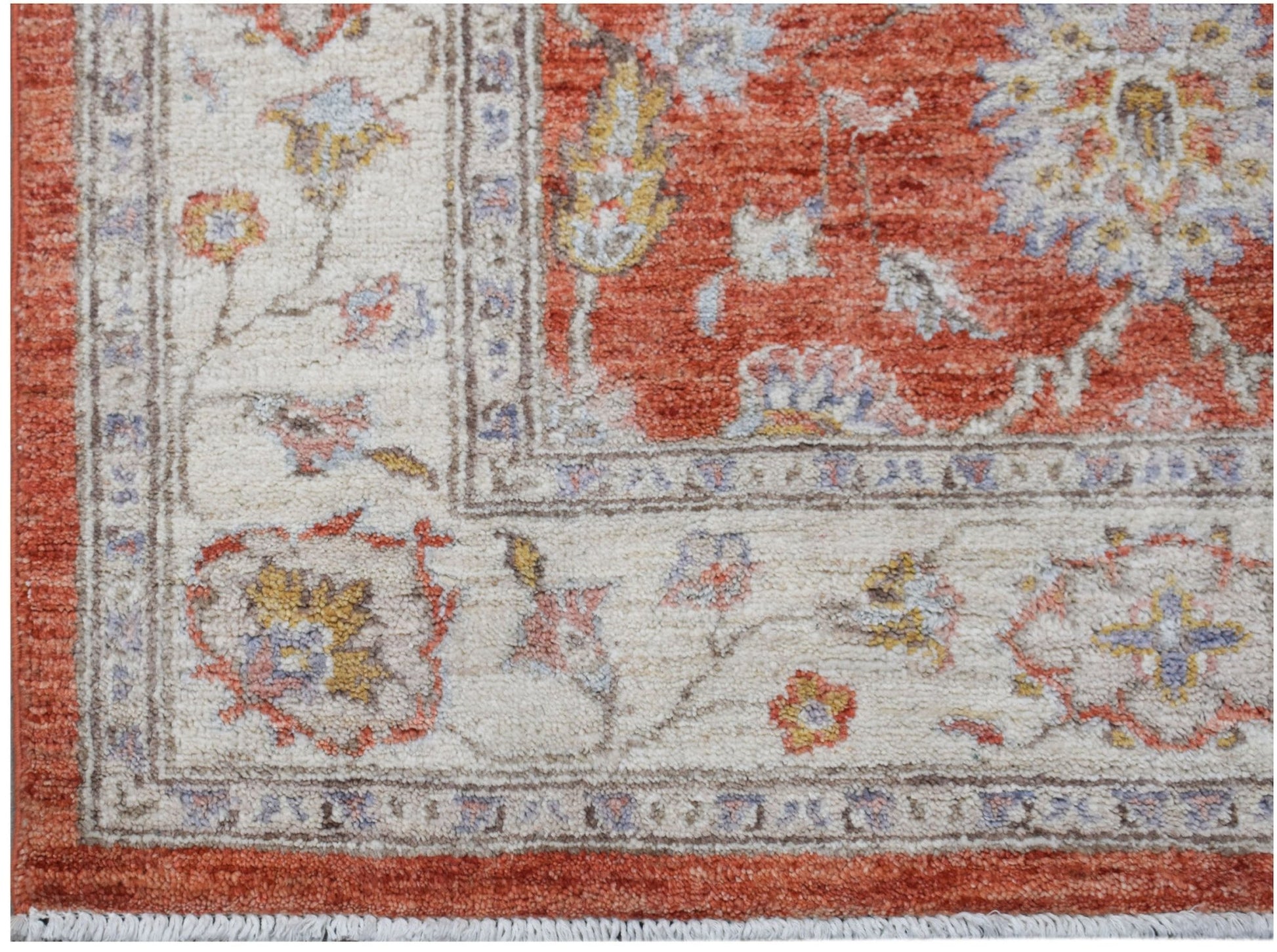 A handwoven Afghan Chobi rug featuring a floral pattern in rust, cream, and soft blue tones.