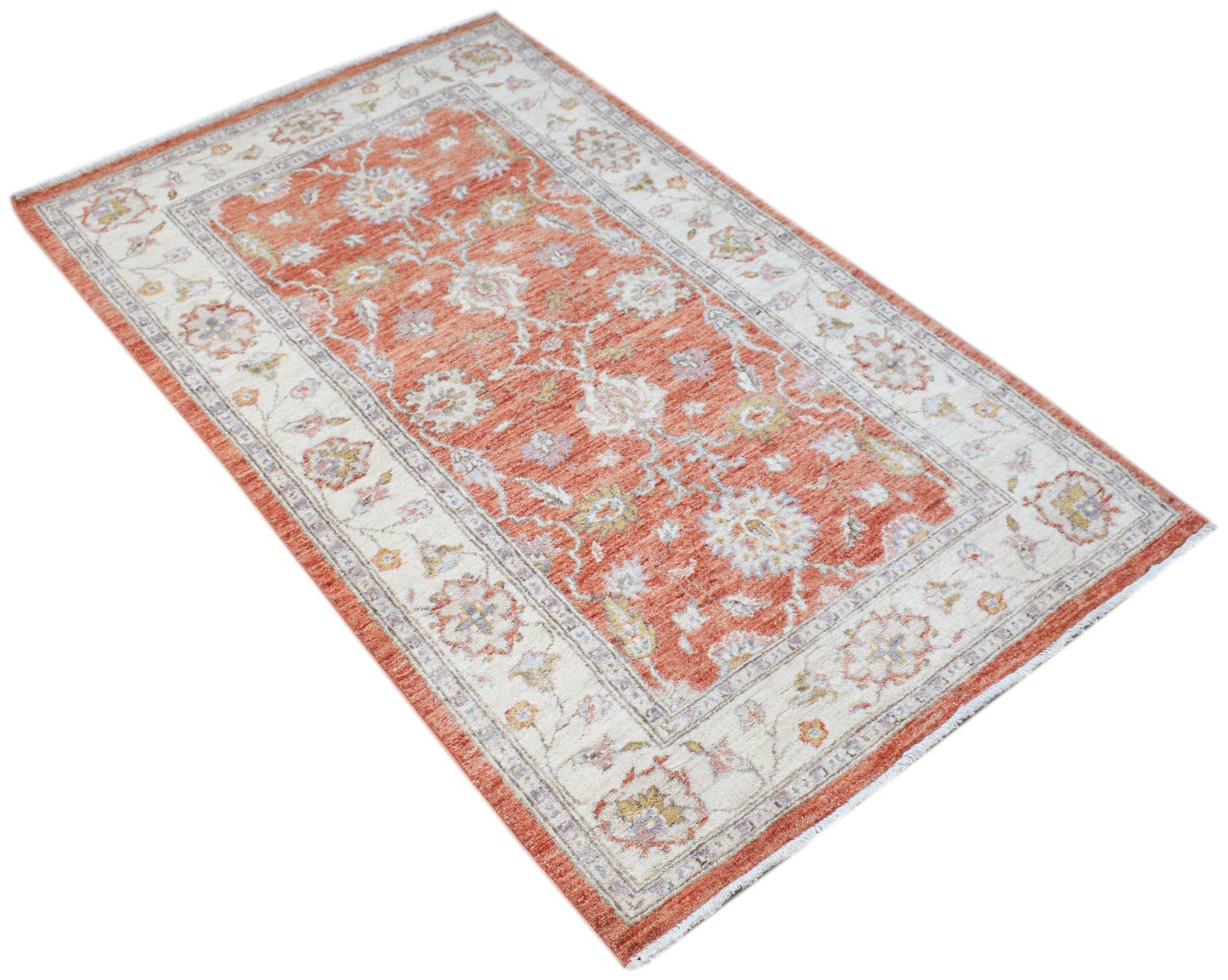 An Afghan Chobi rug featuring a traditional floral pattern in shades of terracotta and cream.