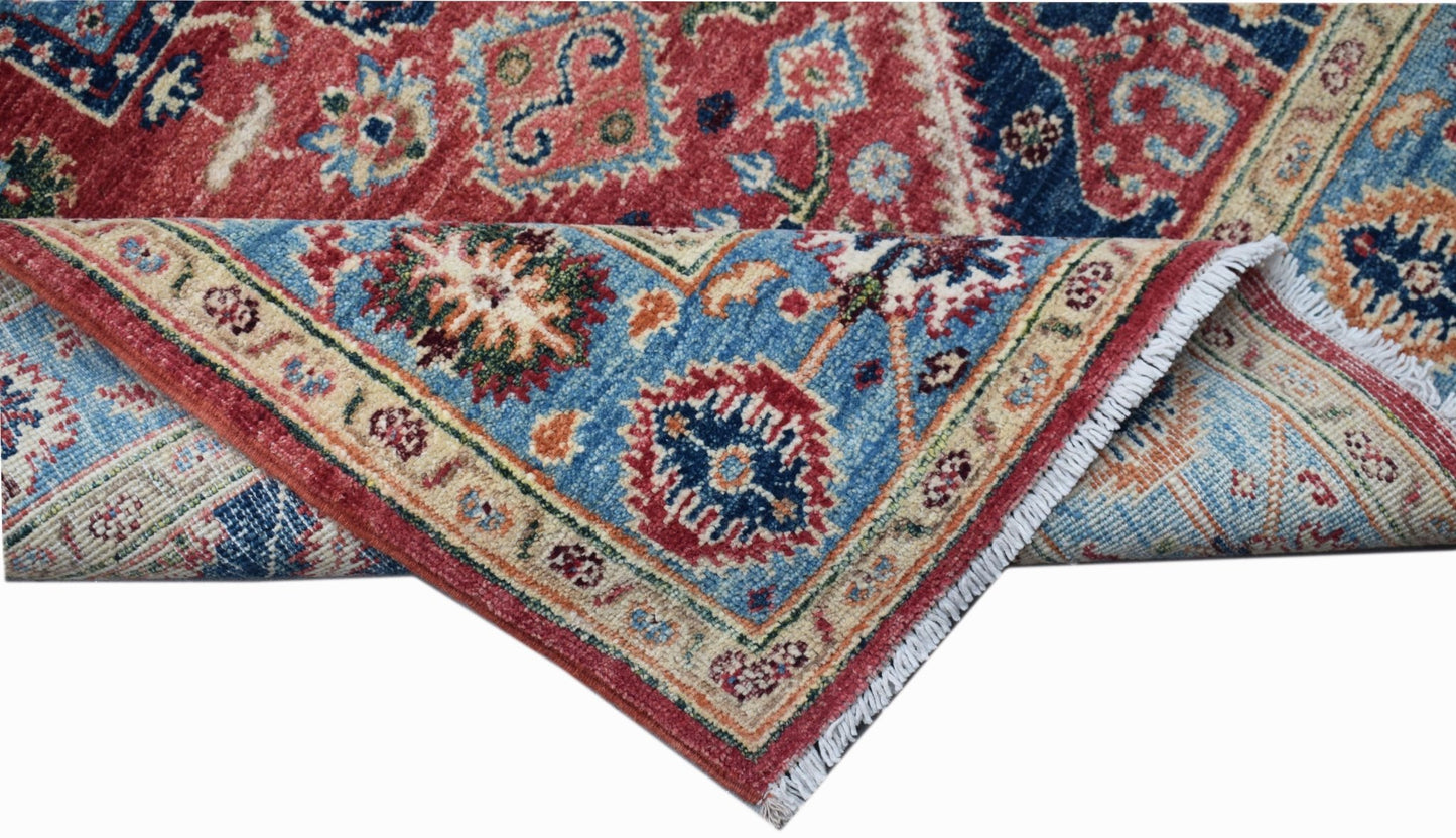 A handwoven Afghan Chobi rug featuring a traditional Heriz pattern in red and blue tones.