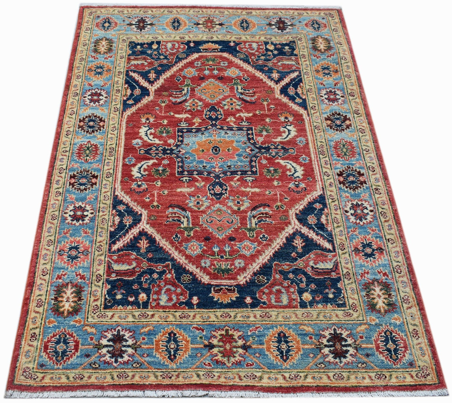 Handwoven Afghan Chobi rug featuring a traditional Heriz pattern in red, blue, and cream tones.