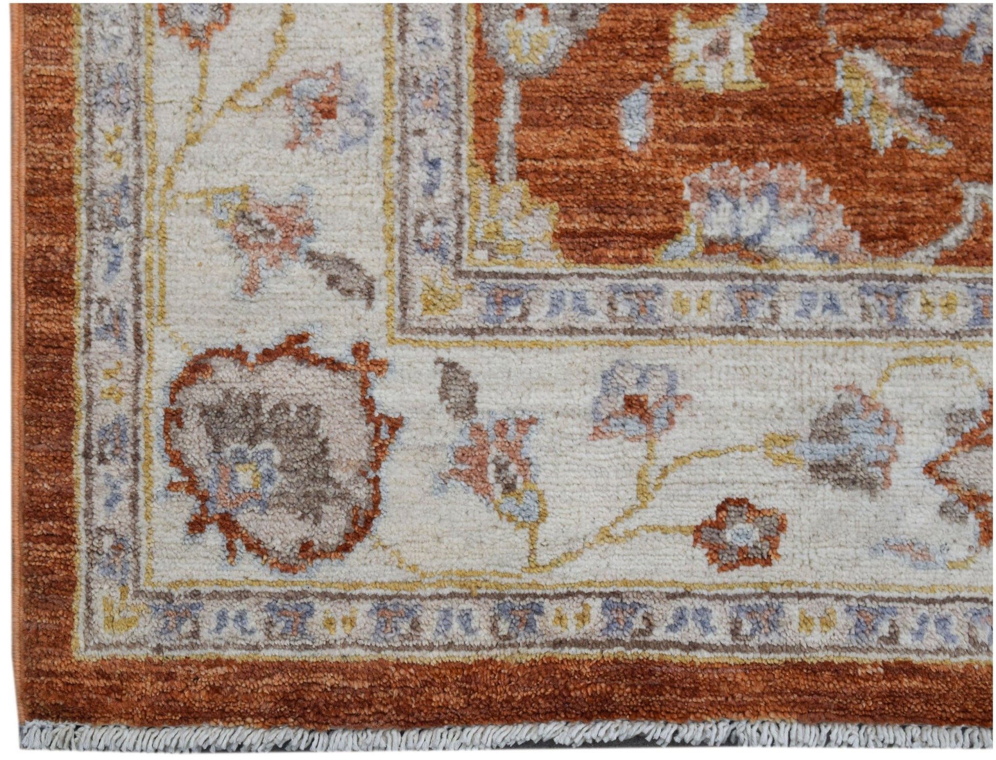 A handmade Afghan Chobi rug featuring a traditional floral pattern in rust and cream tones.