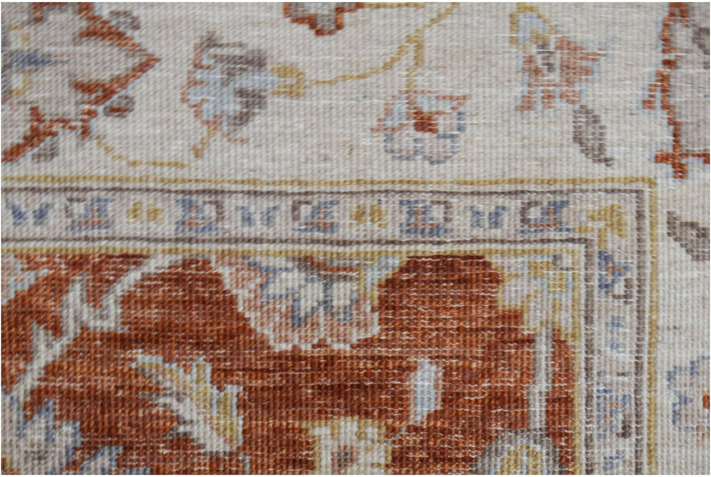 A close-up of a handwoven Afghan Chobi rug featuring traditional floral patterns in earthy tones.