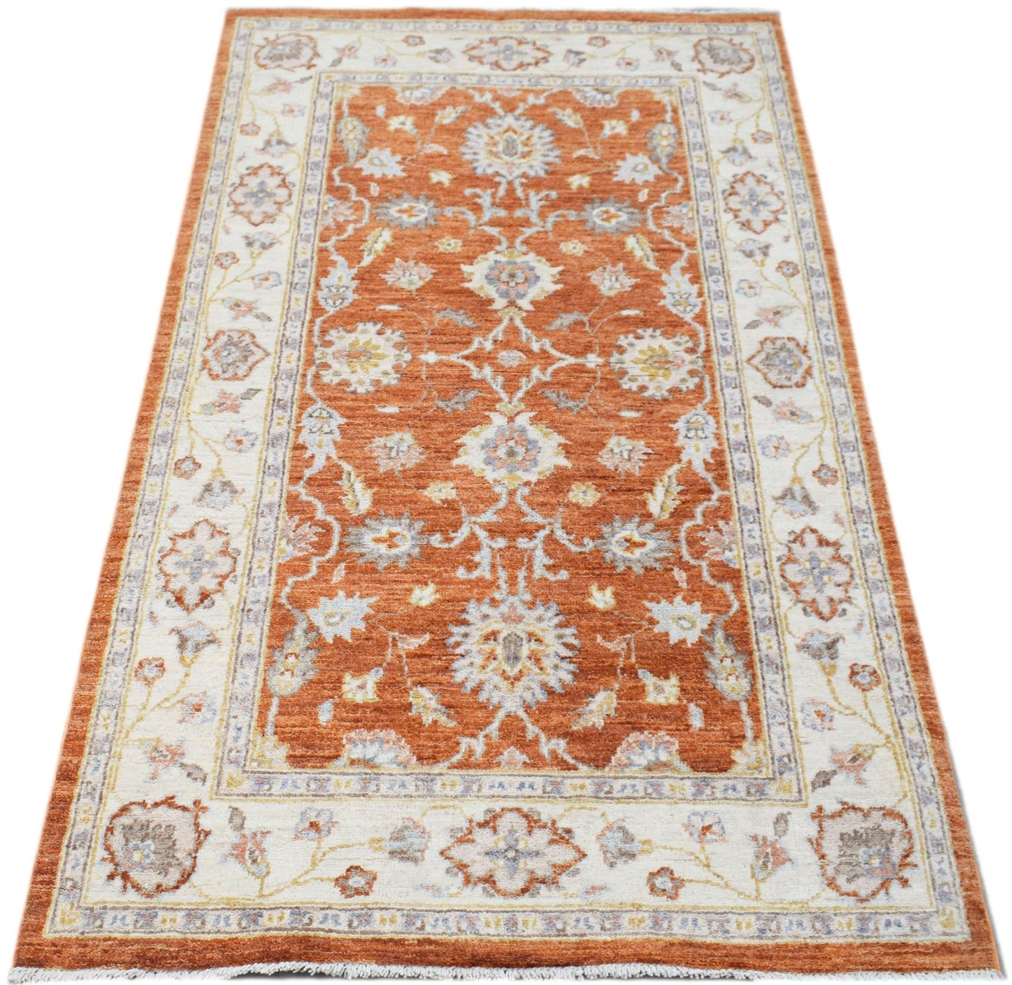An Afghan Chobi rug featuring a traditional floral pattern in shades of orange and cream.